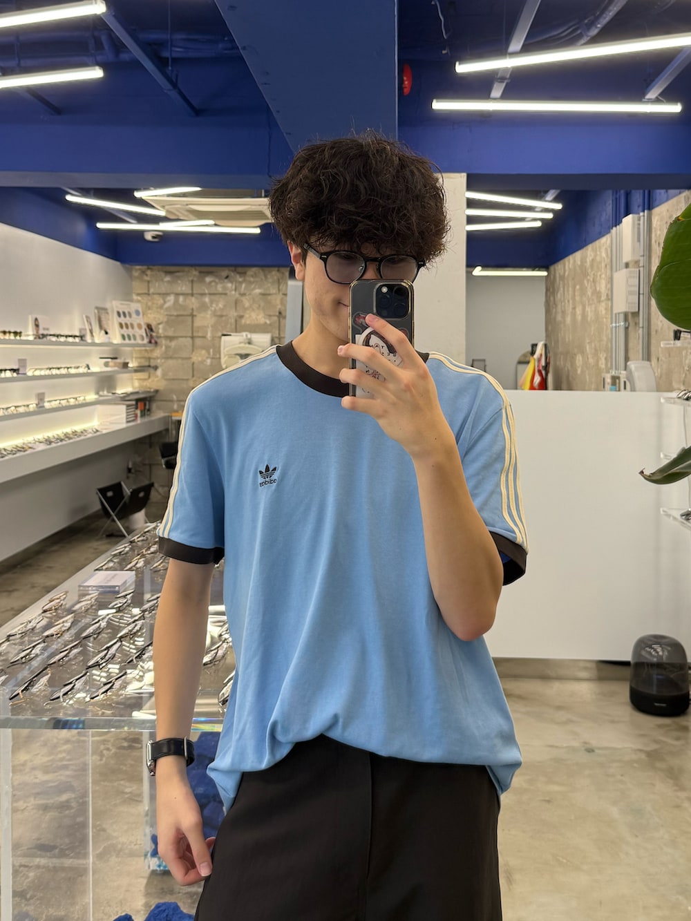 ブルー系のTシャツ/カットソー、グレー系のスラックス、ブラウン系のスニーカーを着用したメンズの秋コーディネートの2枚目の写真