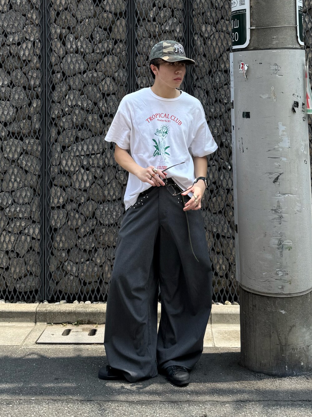 ホワイト系のTシャツ/カットソー、グレー系のスラックス、ブラック系のスニーカーを着用したメンズの夏コーディネートの2枚目の写真