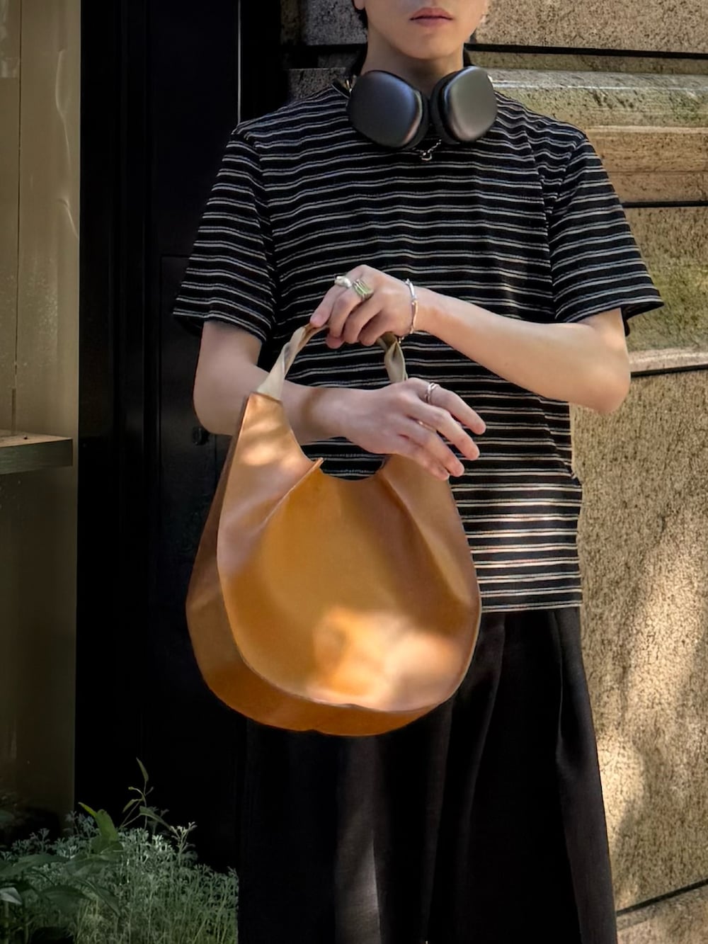 ブラック系のTシャツ/カットソー、ブラック系のスニーカー、ブラウン系のスラックスを着用したメンズの夏コーディネートの4枚目の写真