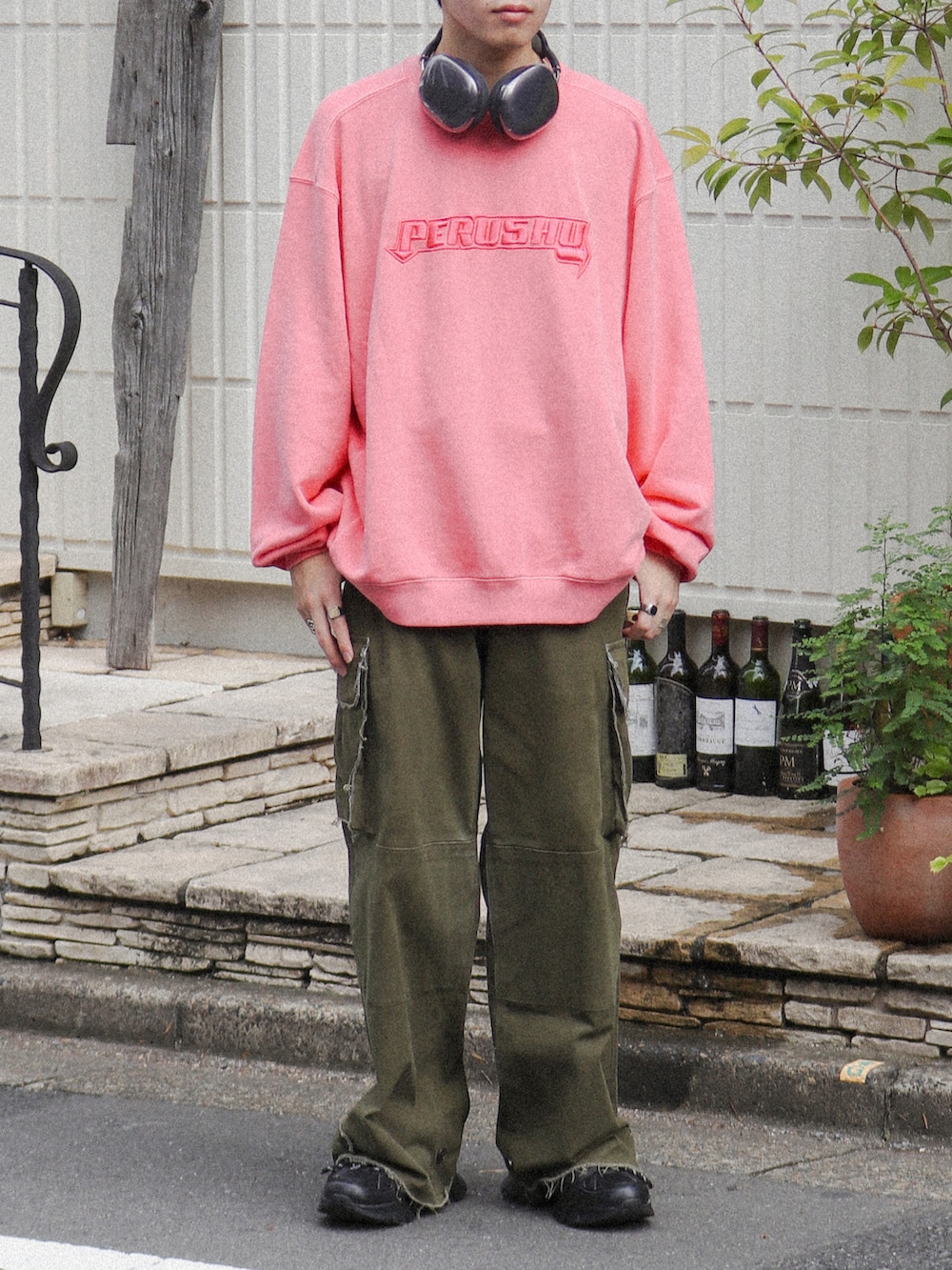 ピンク系のスウェット、グリーン系のカーゴパンツ、ブラック系のスニーカーを着用したメンズの秋コーディネートの5枚目の写真