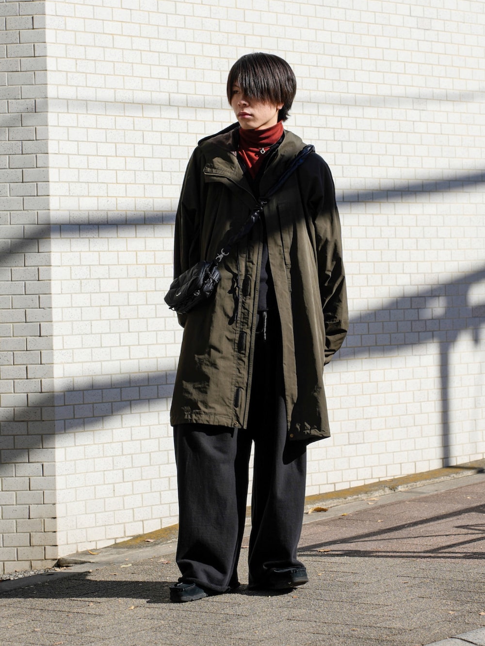 ブラック系のスウェット、ブラック系のショルダーバッグ、ブラック系のスウェットパンツを着用したメンズの冬コーディネートの2枚目の写真