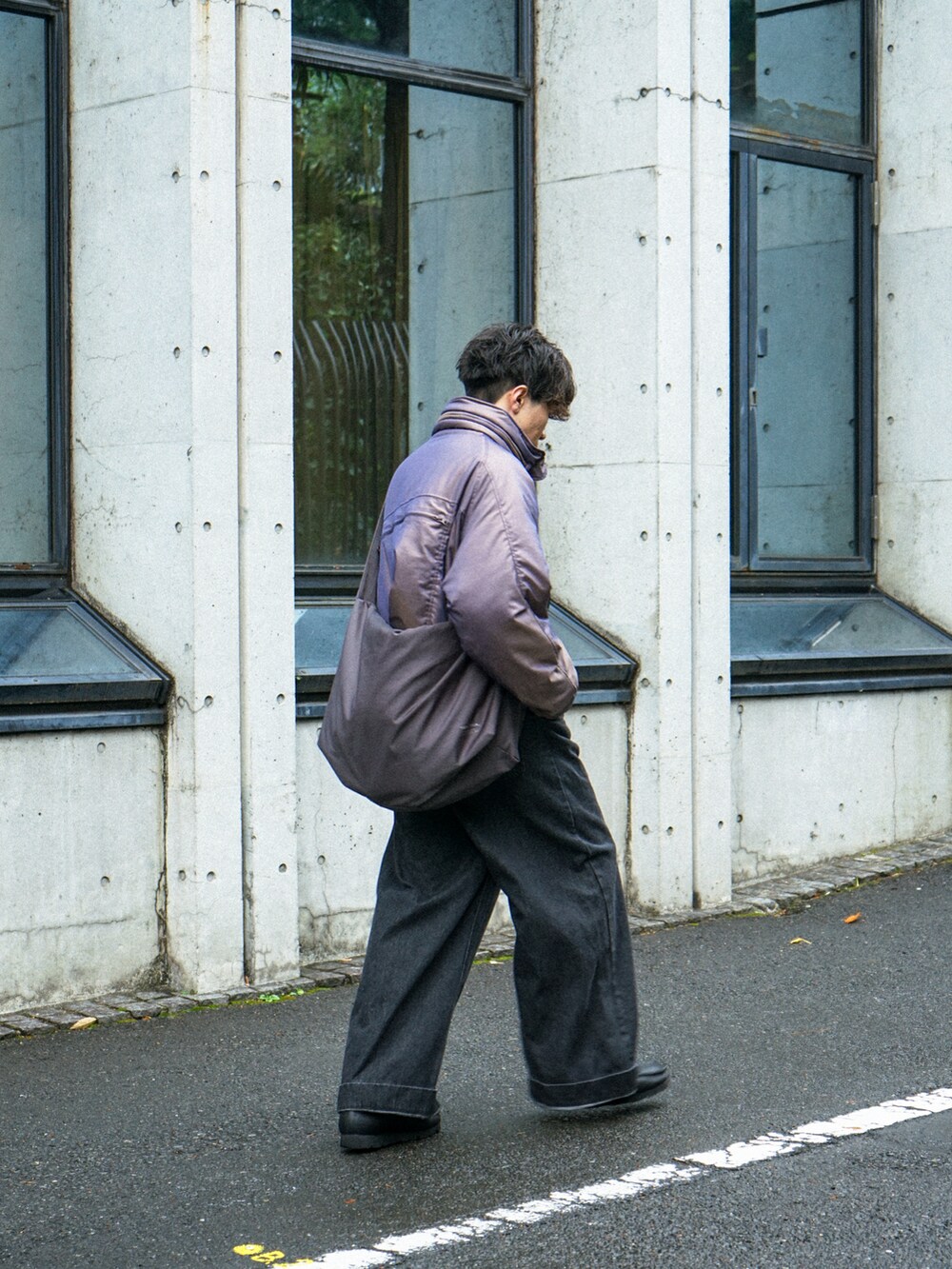 パープル系のブルゾン、ブラック系のデニムパンツ、グレー系のショルダーバッグを着用したメンズの冬コーディネートの4枚目の写真
