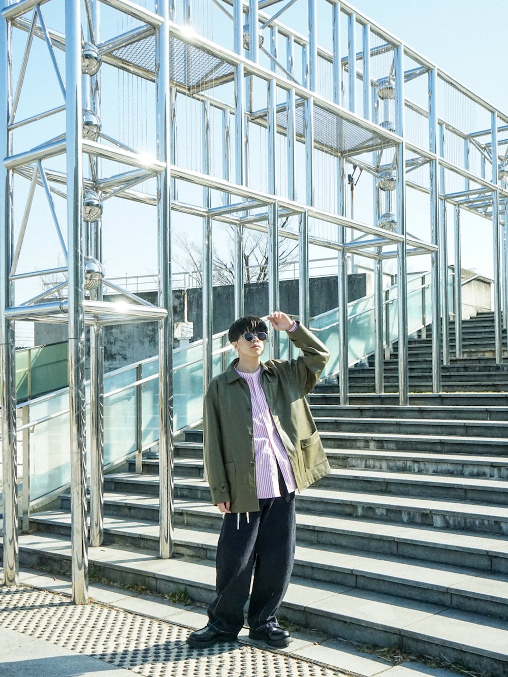 グリーン系のカバーオール、レッド系のシャツ/ブラウス、ブルー系のデニムパンツを着用したメンズの春コーディネートの3枚目の写真