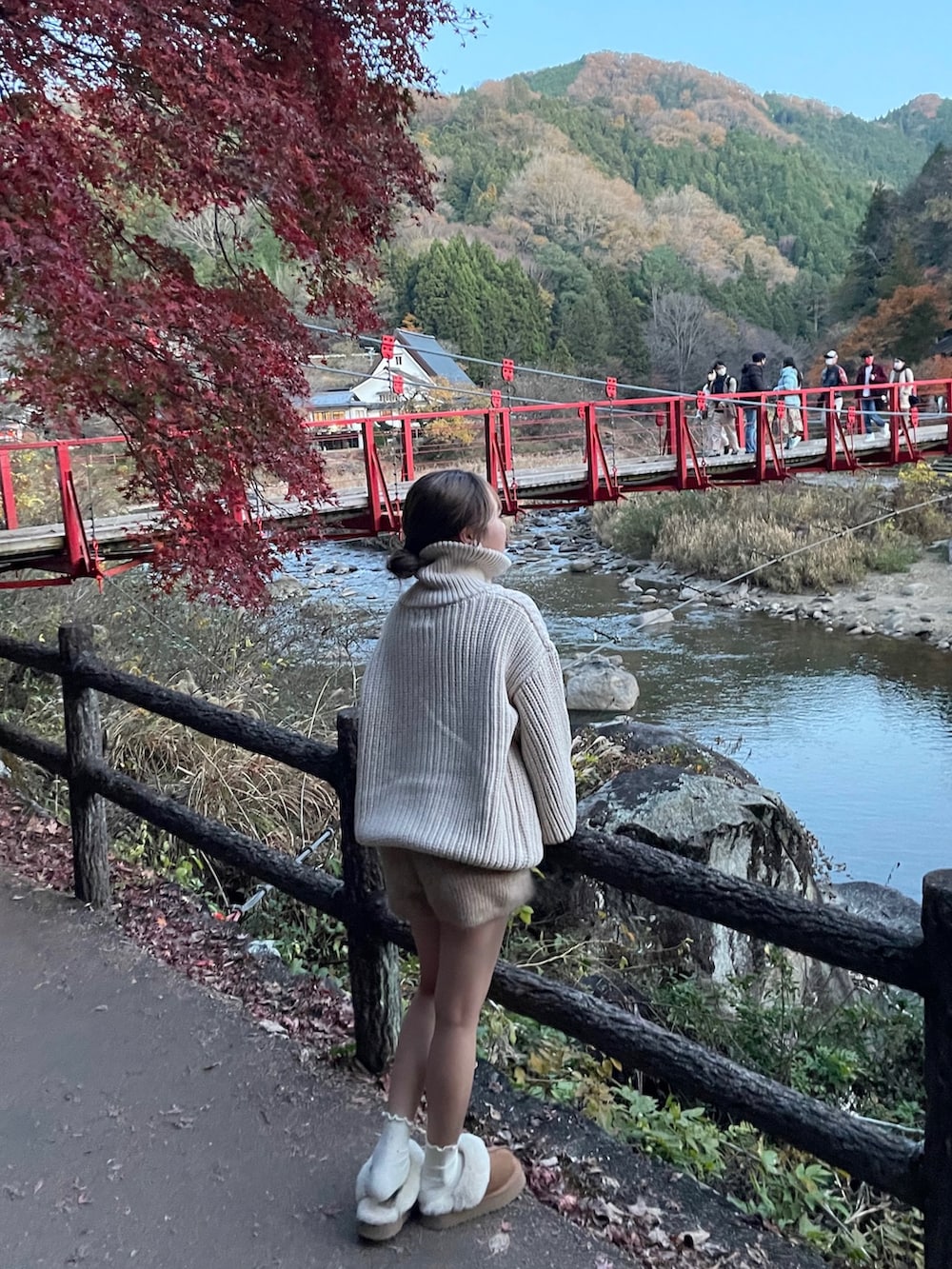 ホワイト系のニット/セーター、ブラウン系のサンダルを着用したレディースの冬コーディネートの2枚目の写真