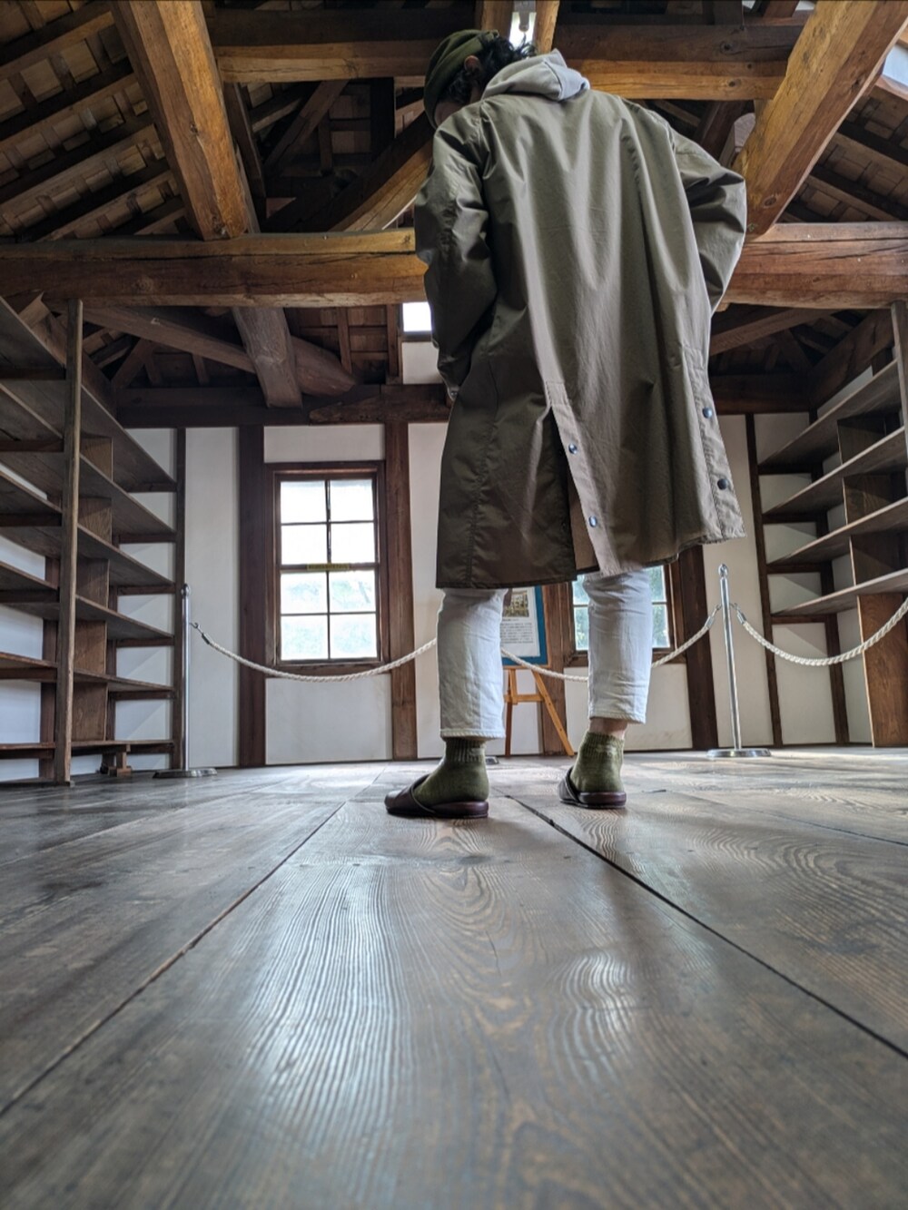 ベージュ系のスニーカー、ホワイト系のデニムパンツ、ベージュ系のパーカーを着用したメンズの秋コーディネートの2枚目の写真