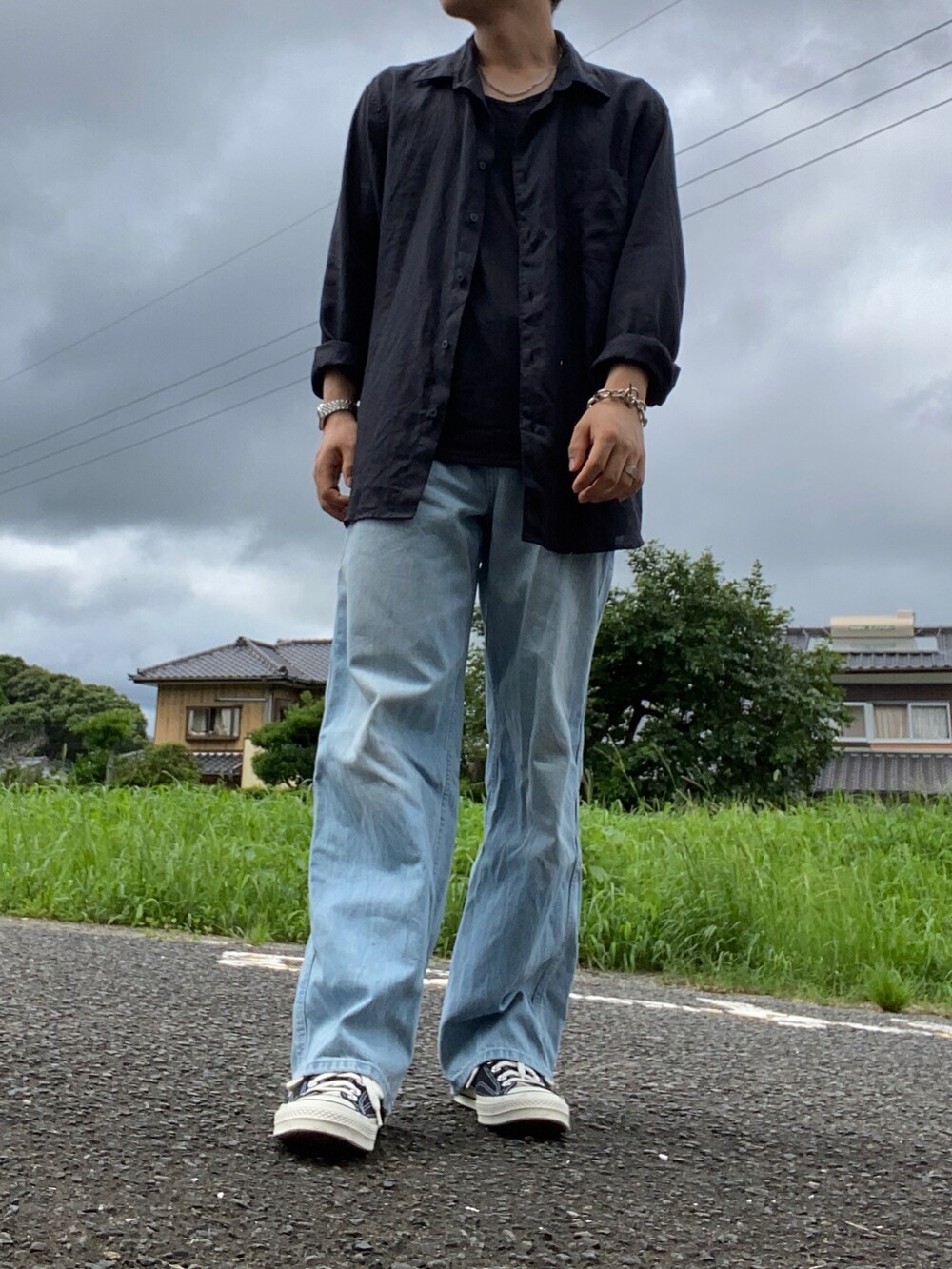 ブラック系のスニーカー、ブルー系のデニムパンツ、ブラック系のシャツ/ブラウスを着用したメンズの夏コーディネートの2枚目の写真