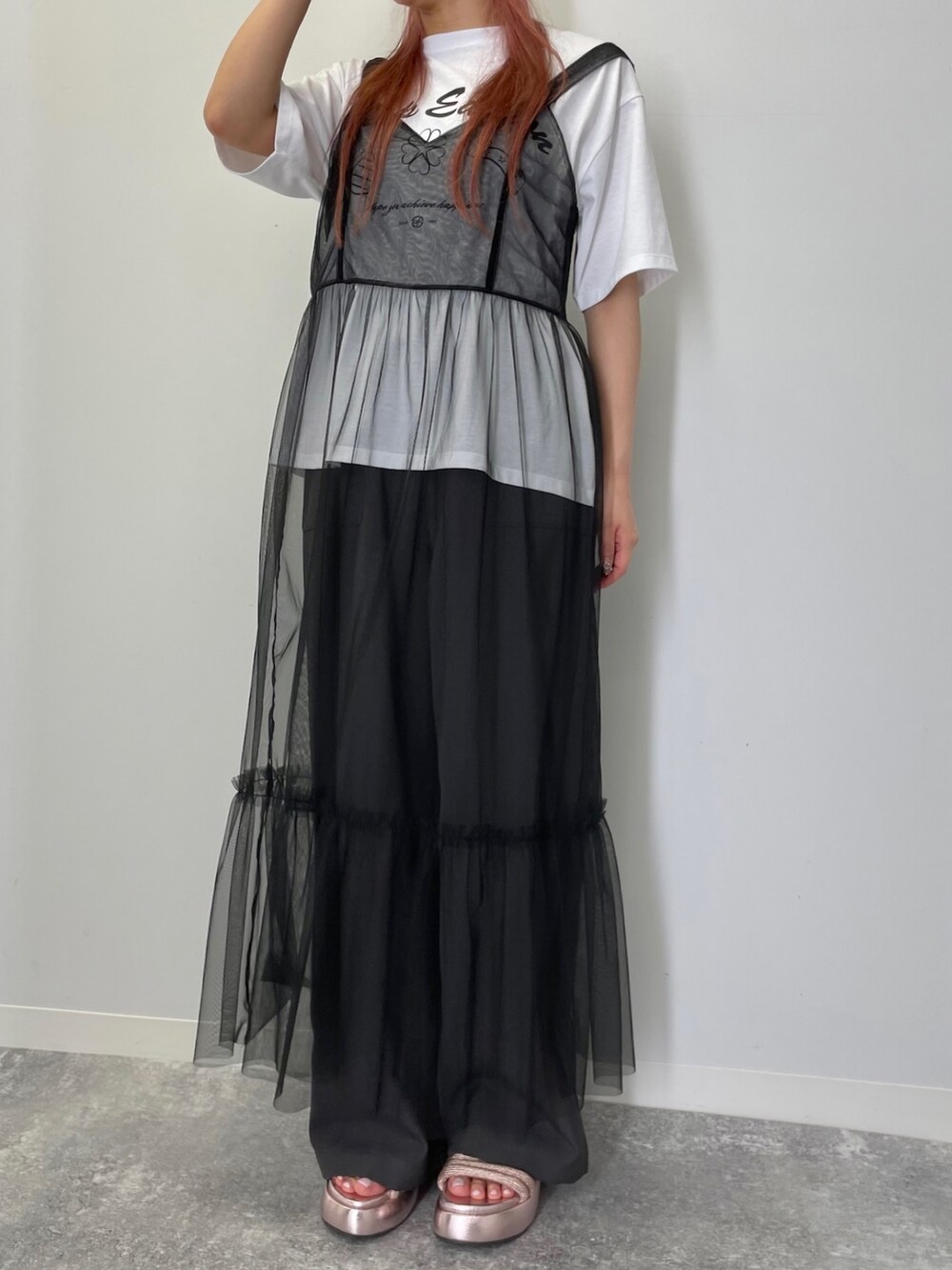 ブラック系のワンピース、ホワイト系のTシャツ/カットソー、ピンク系のサンダルを着用したレディースの夏コーディネートの2枚目の写真
