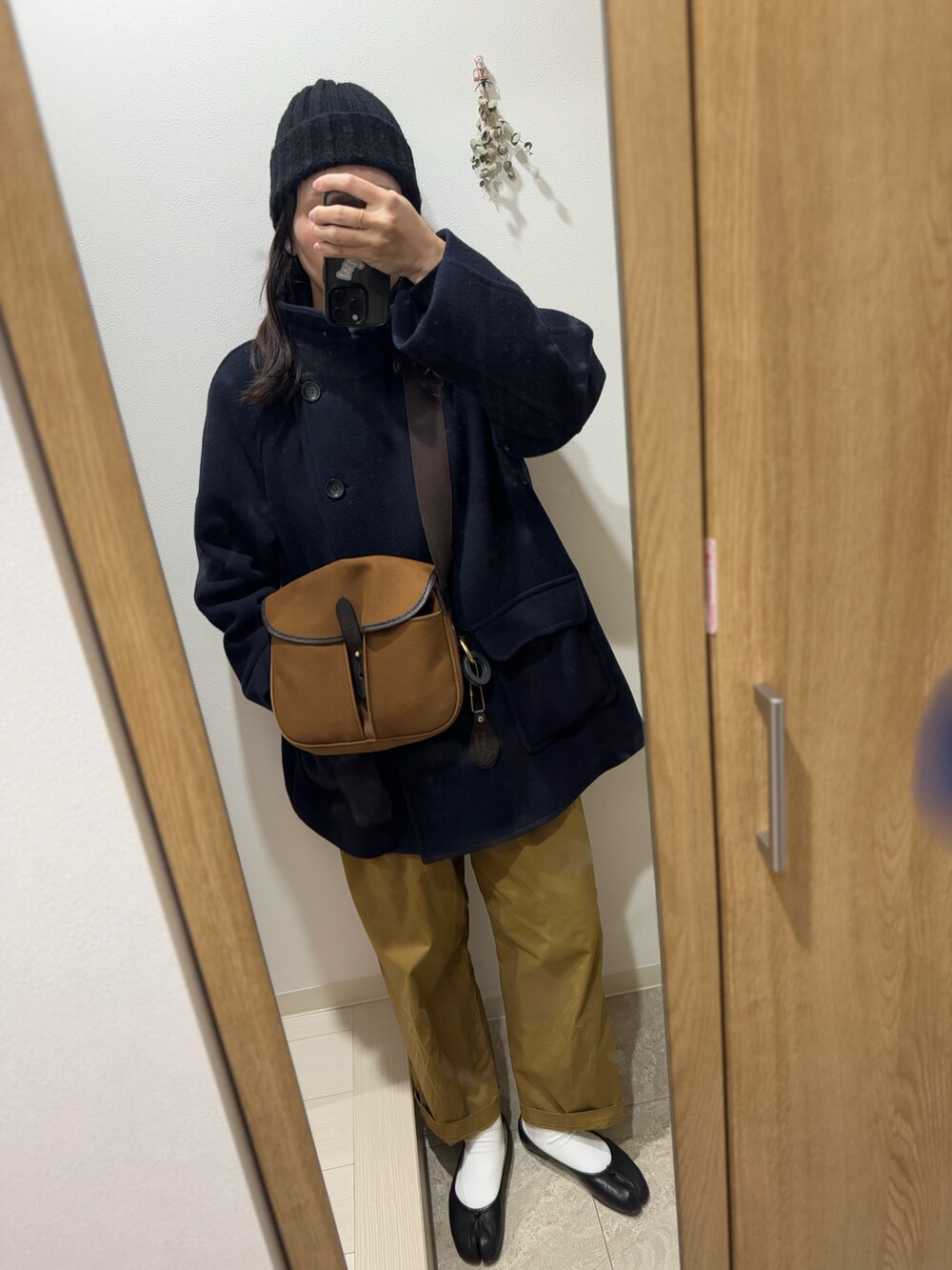 ブラウン系のショルダーバッグ、ブラック系のバレエシューズ、ベージュ系のその他パンツを着用したレディースの冬コーディネートの2枚目の写真