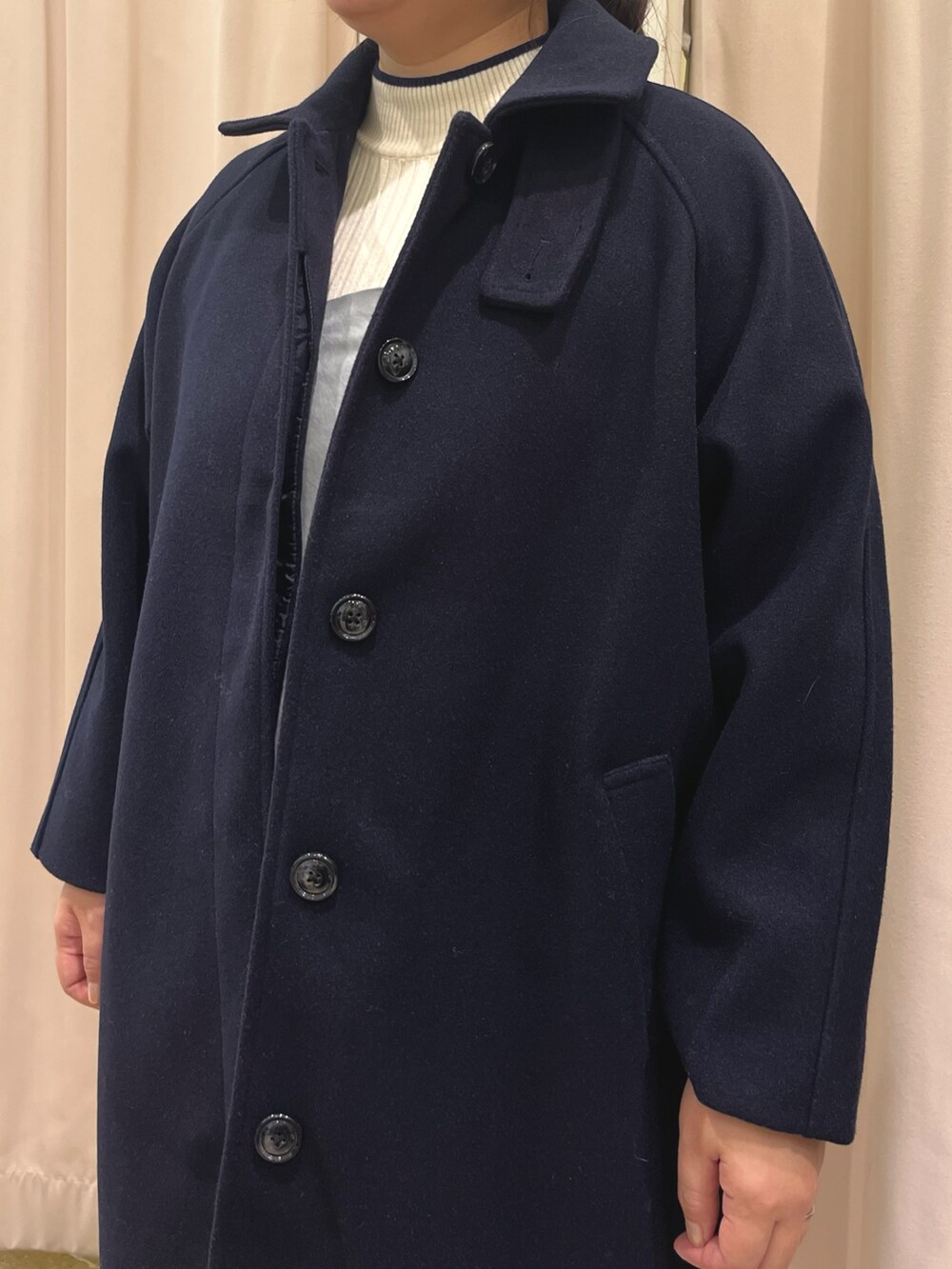 ブルー系のステンカラーコート、ブラック系のブーツ、グレー系のワンピースを着用したレディースの冬コーディネートの2枚目の写真