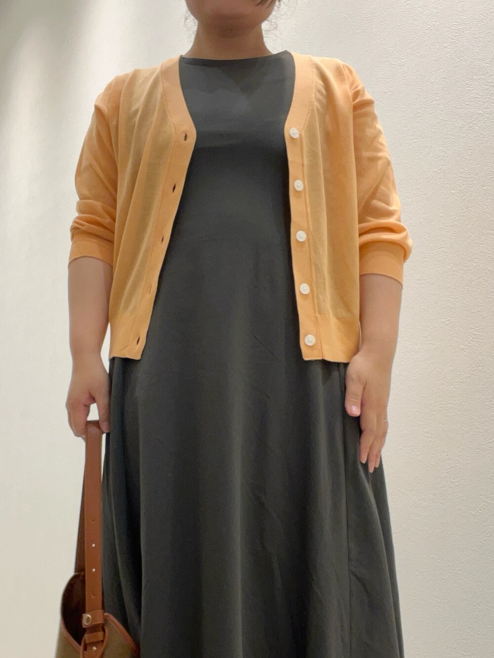 オレンジ系のカーディガン/ボレロ、ブラウン系のハンドバッグ、ホワイト系のサンダルを着用したレディースの夏コーディネートの2枚目の写真