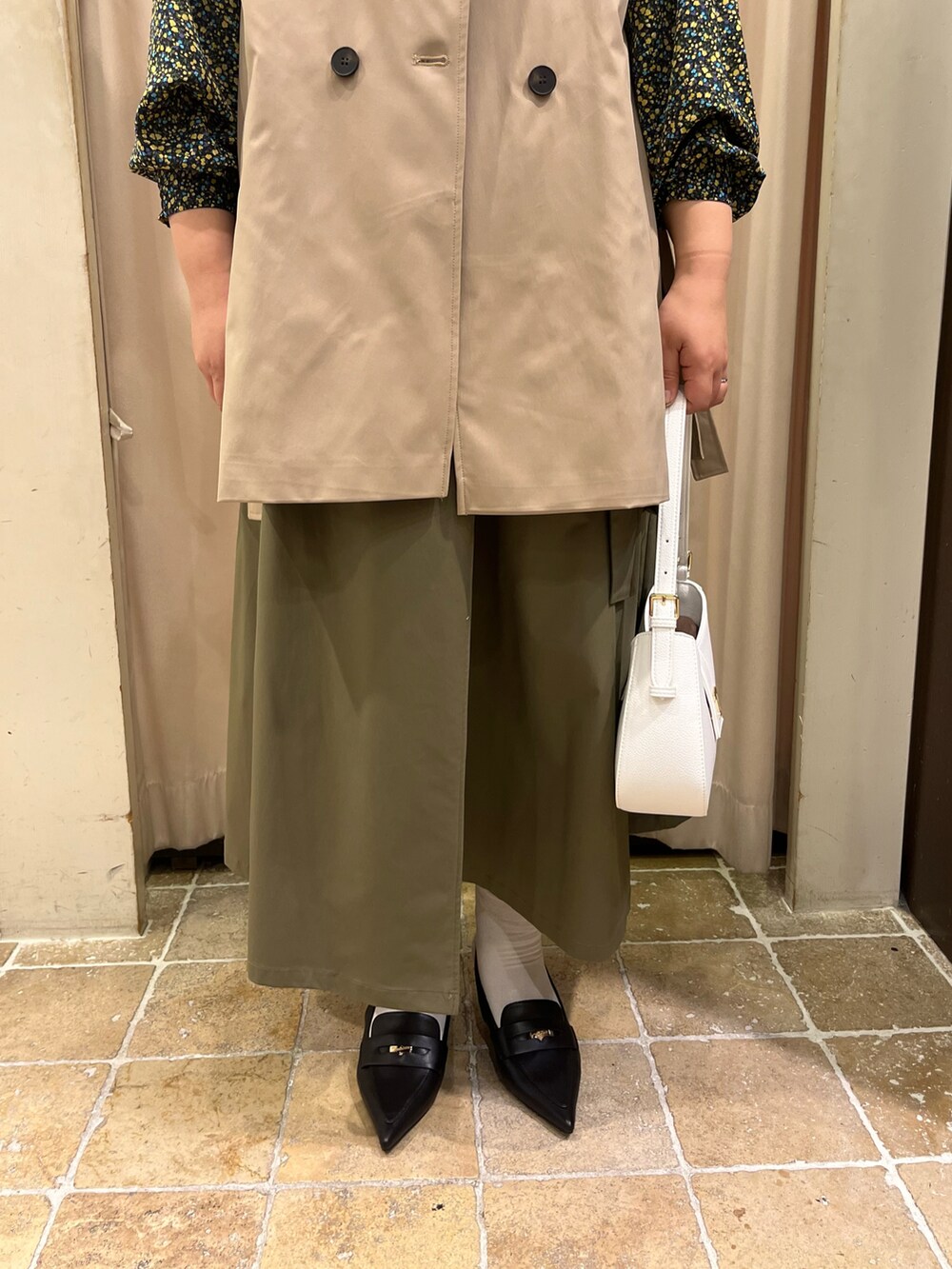 ベージュ系のベスト、イエロー系のシャツ/ブラウス、グリーン系のスカートを着用したレディースの冬コーディネートの4枚目の写真