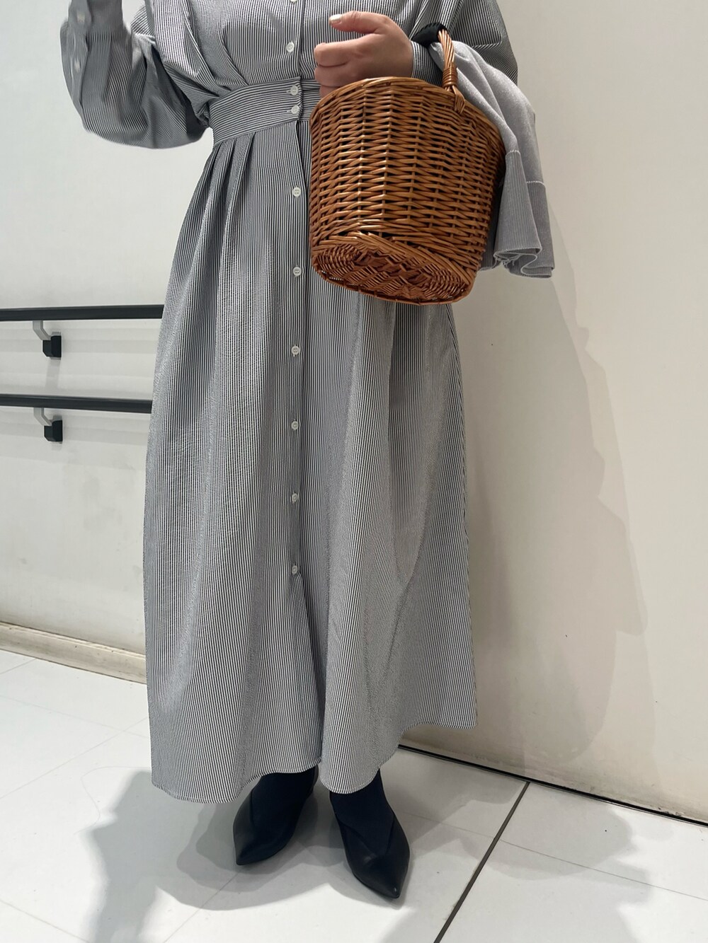 ブラック系のパンプス、ブラック系のワンピース、ブラウン系のハンドバッグを着用したレディースの春コーディネートの4枚目の写真