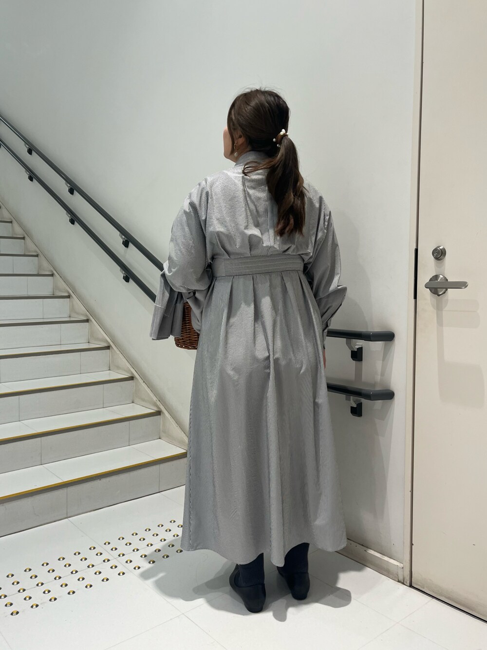 ブラック系のパンプス、ブラック系のワンピース、ブラウン系のハンドバッグを着用したレディースの春コーディネートの2枚目の写真