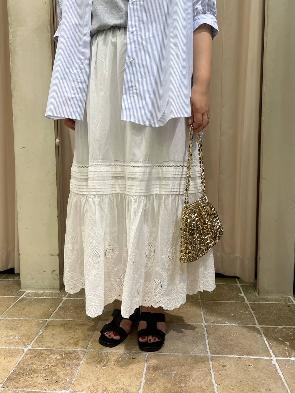 ブルー系のシャツ/ブラウス、ホワイト系のスカート、ブラック系のサンダルを着用したレディースの春コーディネートの3枚目の写真