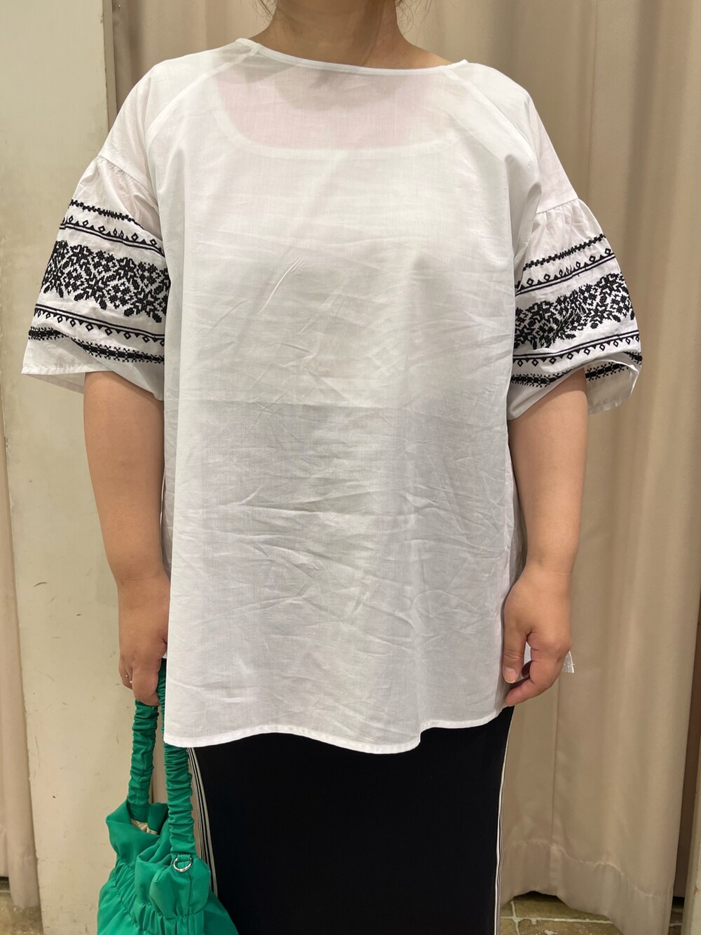 ホワイト系のシャツ/ブラウス、ブラック系のスカート、パープル系のスニーカーを着用したレディースの夏コーディネートの2枚目の写真