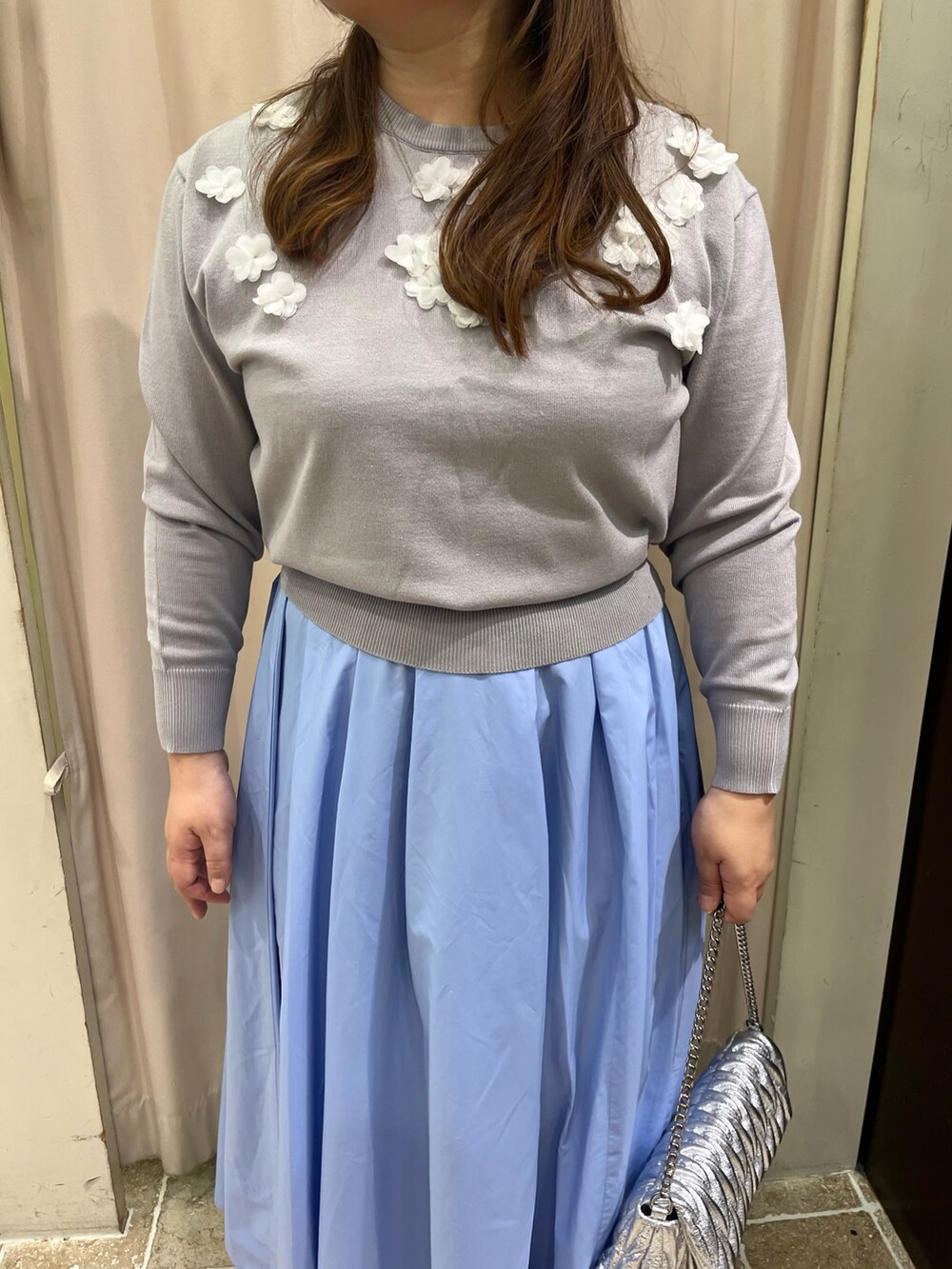 ブラック系のパンプス、グレー系のニット/セーター、ブルー系のスカートを着用したレディースの冬コーディネートの2枚目の写真