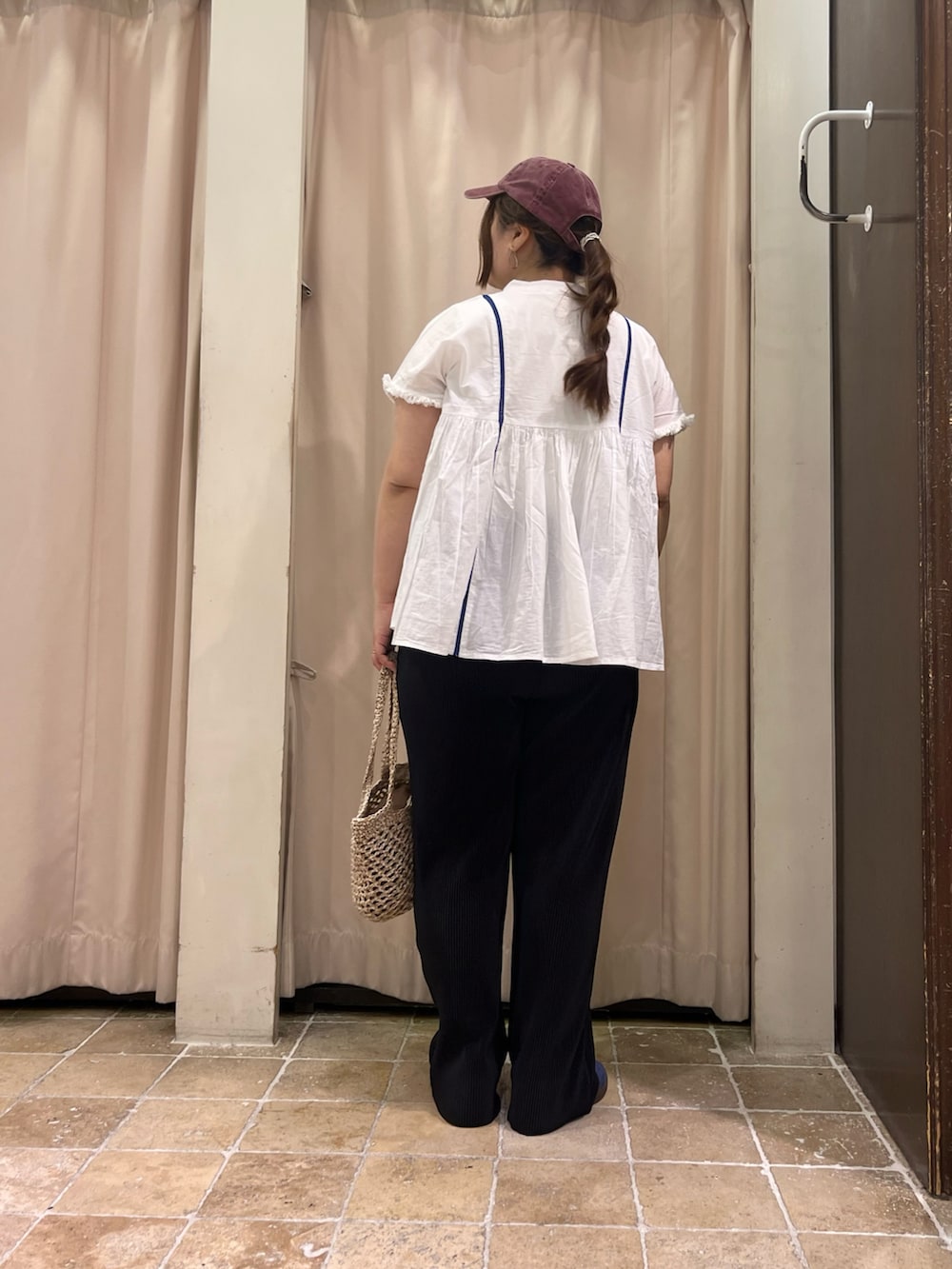 ベージュ系のハンドバッグ、ブラック系のその他パンツ、ブルー系のスニーカーを着用したレディースの春コーディネートの3枚目の写真