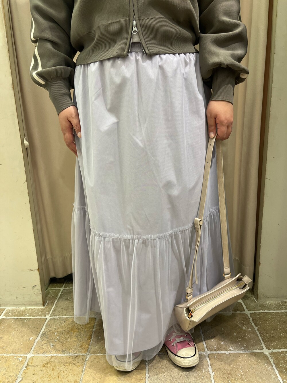 ピンク系のスニーカー、グレー系のスカート、ホワイト系のハンドバッグを着用したレディースの春コーディネートの5枚目の写真