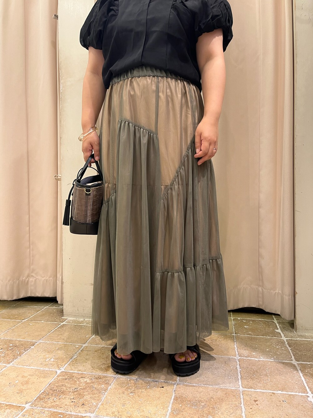 ブラック系のサンダル、ブラック系のシャツ/ブラウス、グリーン系のスカートを着用したレディースの夏コーディネートの3枚目の写真