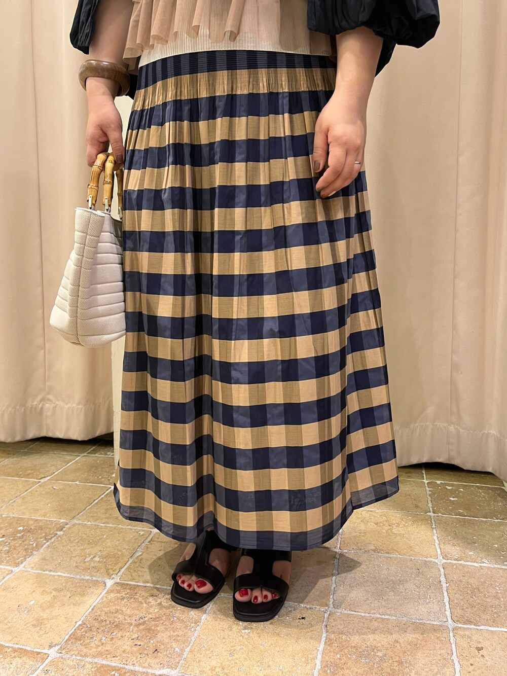 ブラウン系のシャツ/ブラウス、ブルー系のスカート、ブラック系のブルゾンを着用したレディースの春コーディネートの3枚目の写真