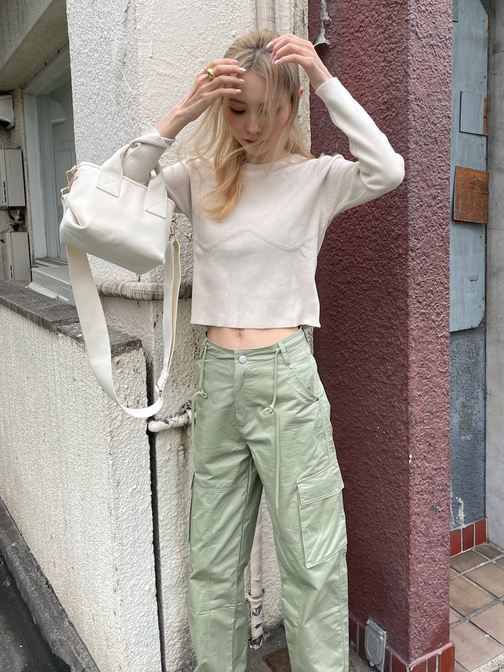 ホワイト系のニット/セーター、グリーン系のカーゴパンツ、ブラック系のスニーカーを着用したレディースの秋コーディネートの2枚目の写真