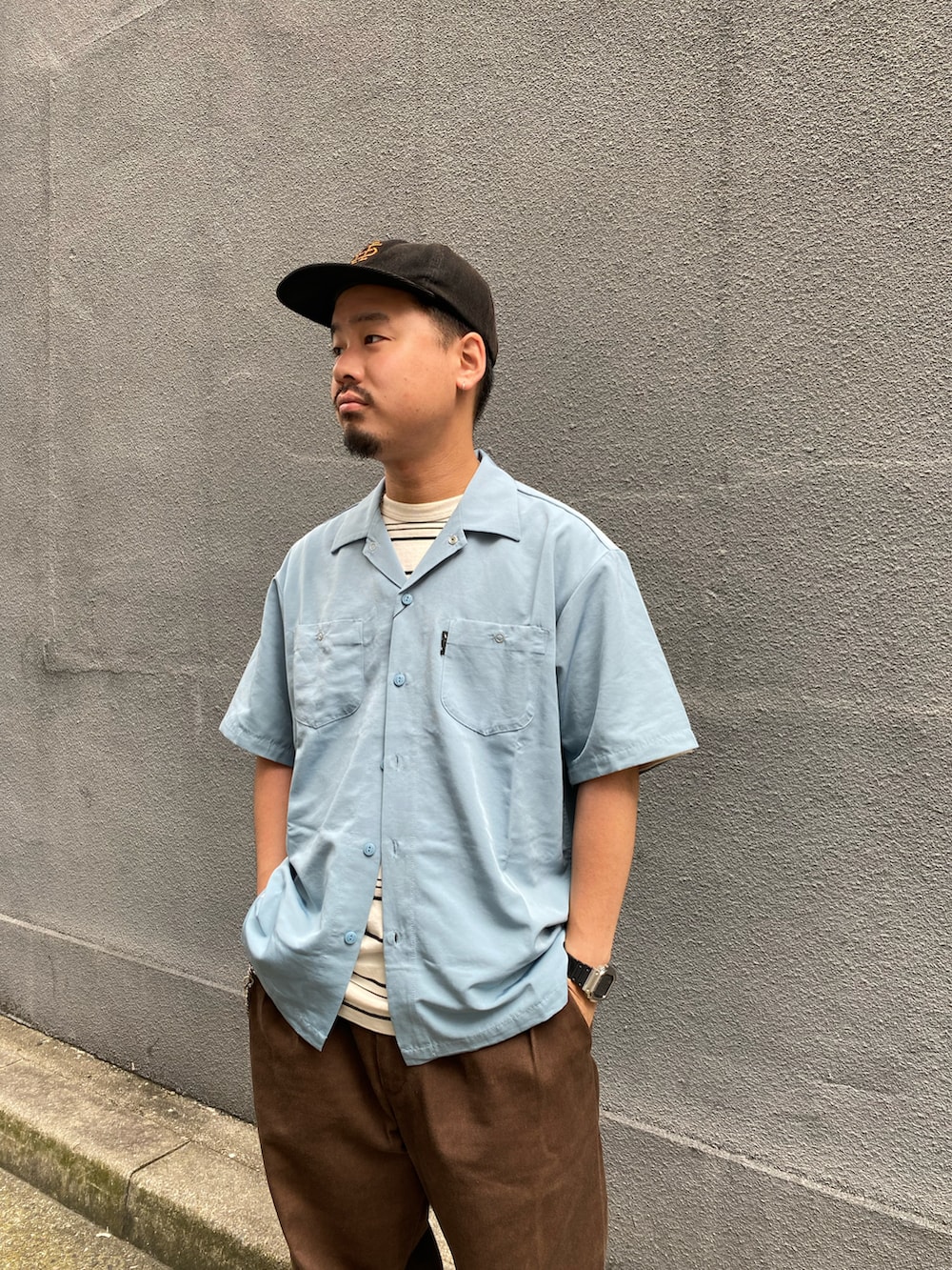 ブラウン系のチノパンツ、ブルー系のシャツ/ブラウスを着用したメンズの夏コーディネートの2枚目の写真