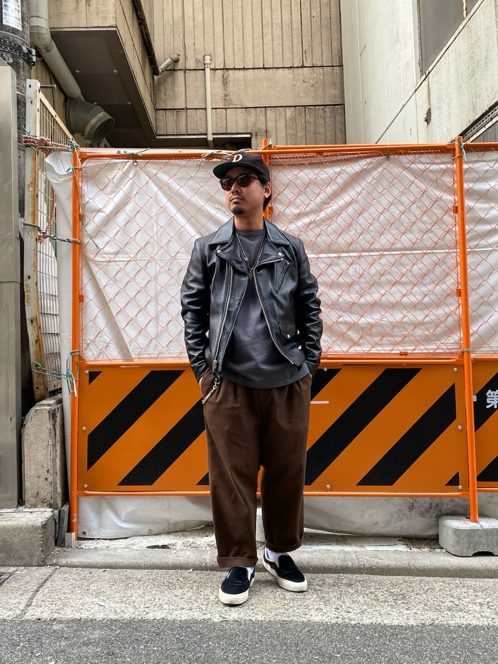 ブラック系のライダースジャケット、ブラウン系のチノパンツを着用したメンズの冬コーディネートの2枚目の写真