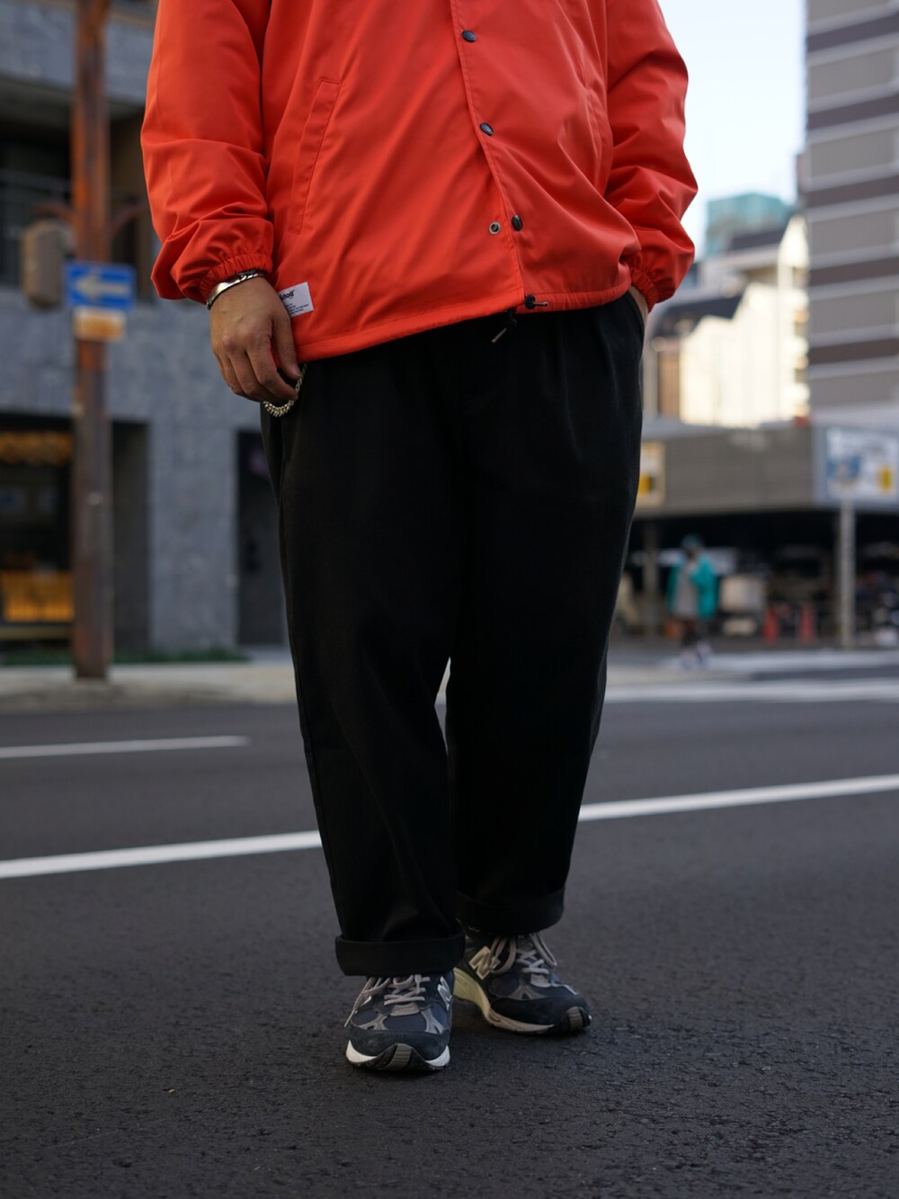 ブラック系のその他パンツ、オレンジ系のナイロンジャケットを着用したメンズの冬コーディネートの3枚目の写真