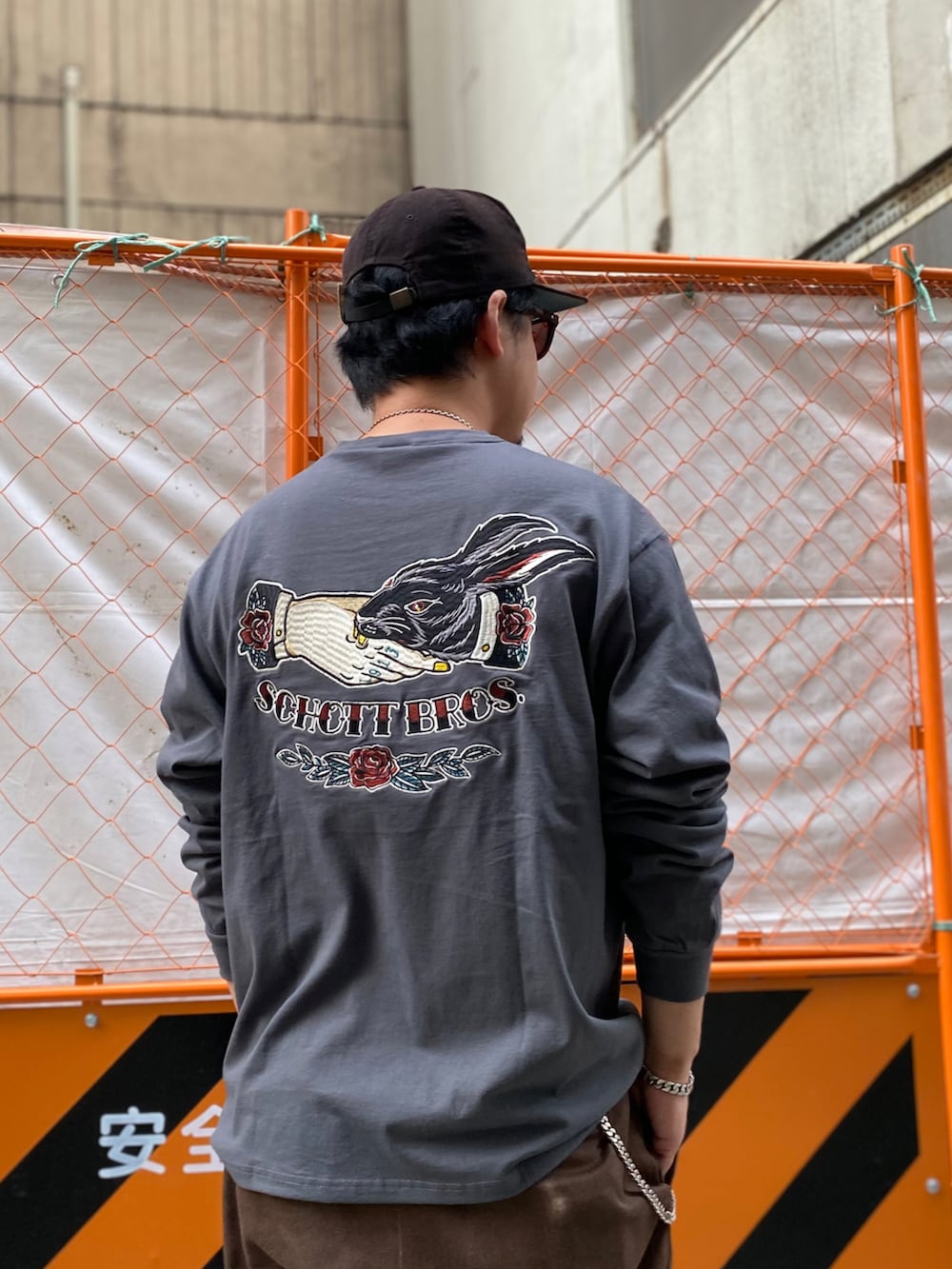 ブラウン系のチノパンツ、グレー系のTシャツ/カットソーを着用したメンズの冬コーディネートの2枚目の写真