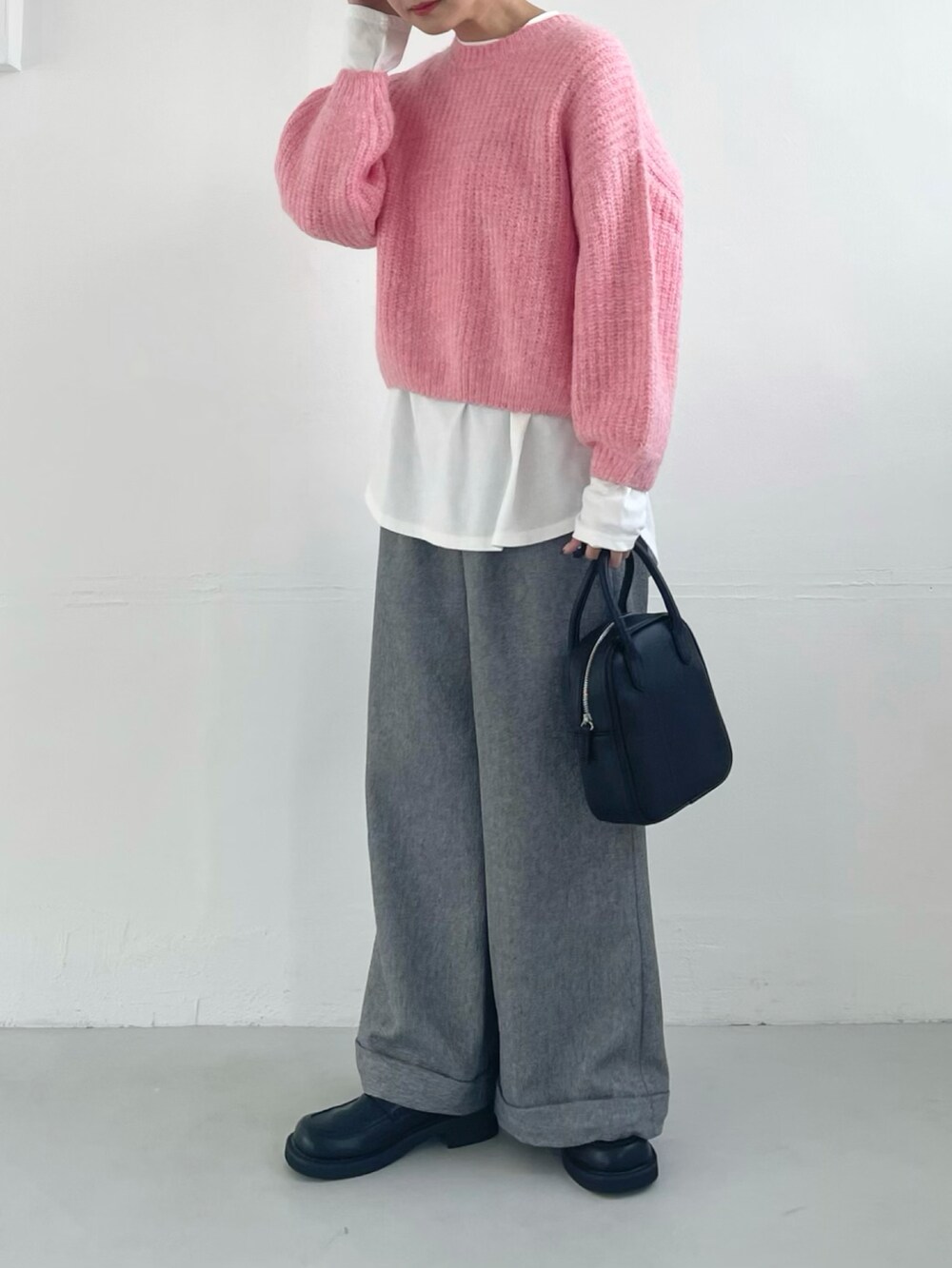 ピンク系のニット/セーター、ホワイト系のスウェット、グレー系のスラックスを着用したレディースの秋コーディネートの2枚目の写真
