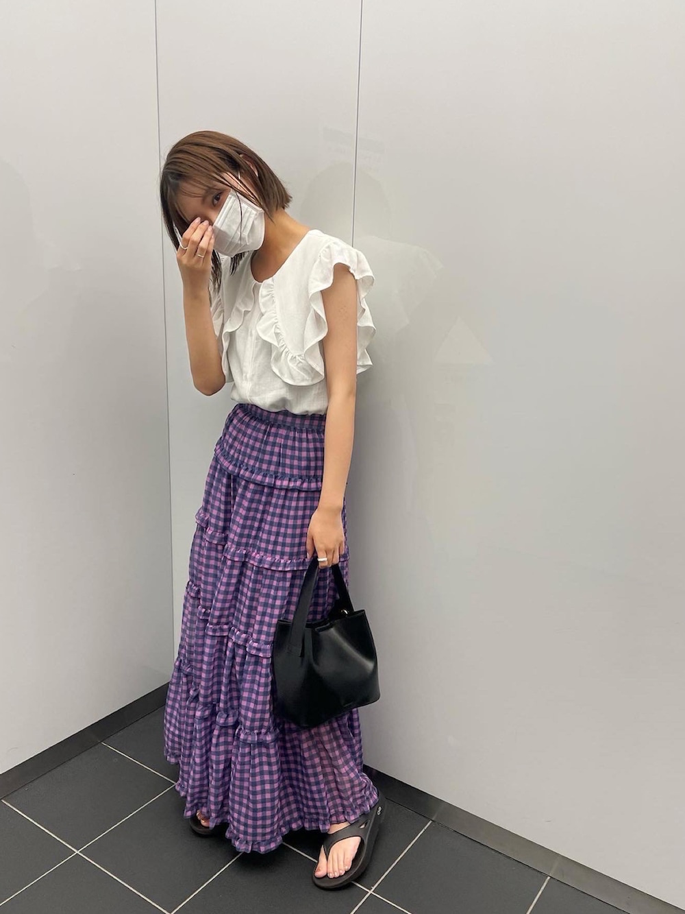 ホワイト系のシャツ/ブラウス、ブラック系のハンドバッグ、ピンク系のスカートを着用したレディースの夏コーディネートの2枚目の写真