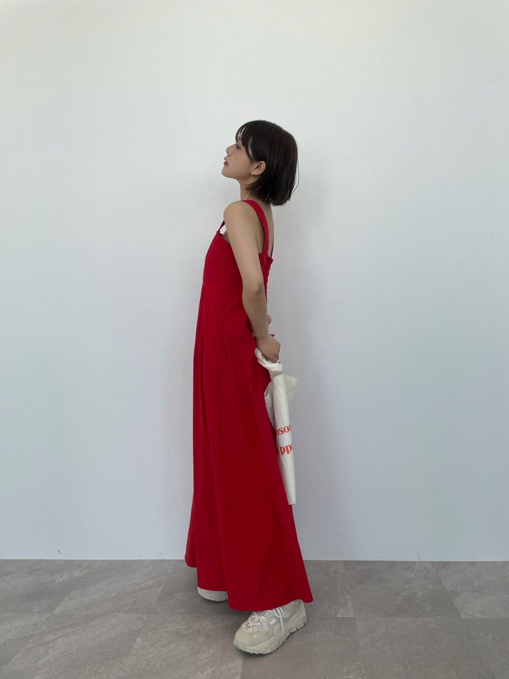 レッド系のワンピース、ホワイト系のスニーカーを着用したレディースの春コーディネートの2枚目の写真