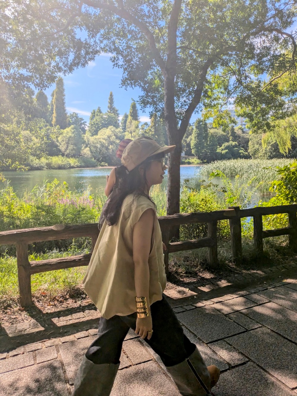 ベージュ系のベスト、ブラック系のデニムパンツ、ブラウン系のブーツを着用したレディースの秋コーディネートの3枚目の写真