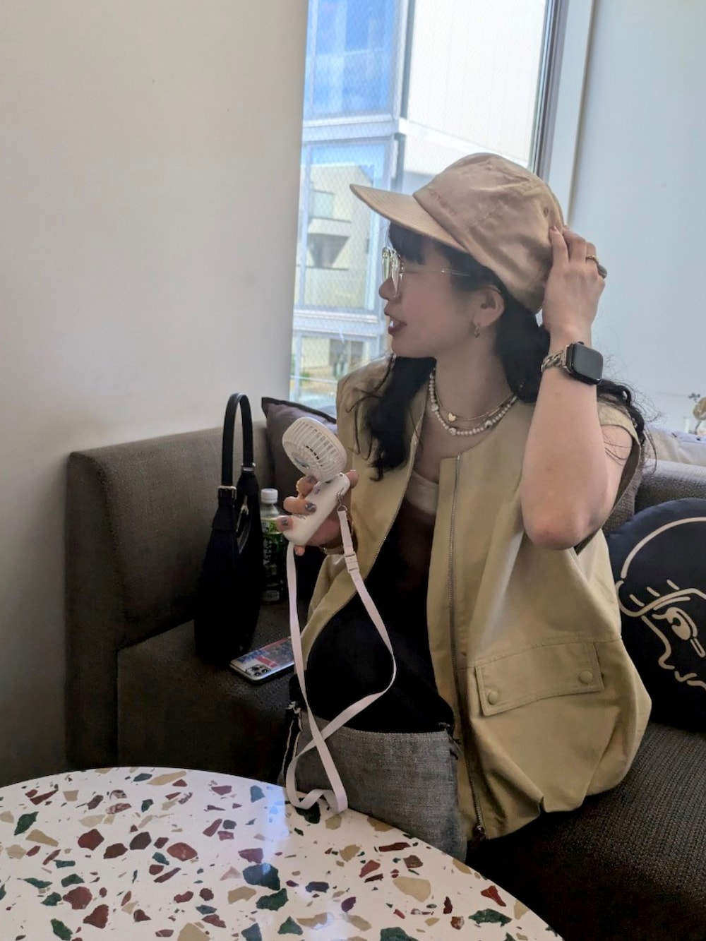 ベージュ系のベスト、ブラック系のデニムパンツ、ブラウン系のブーツを着用したレディースの秋コーディネートの5枚目の写真