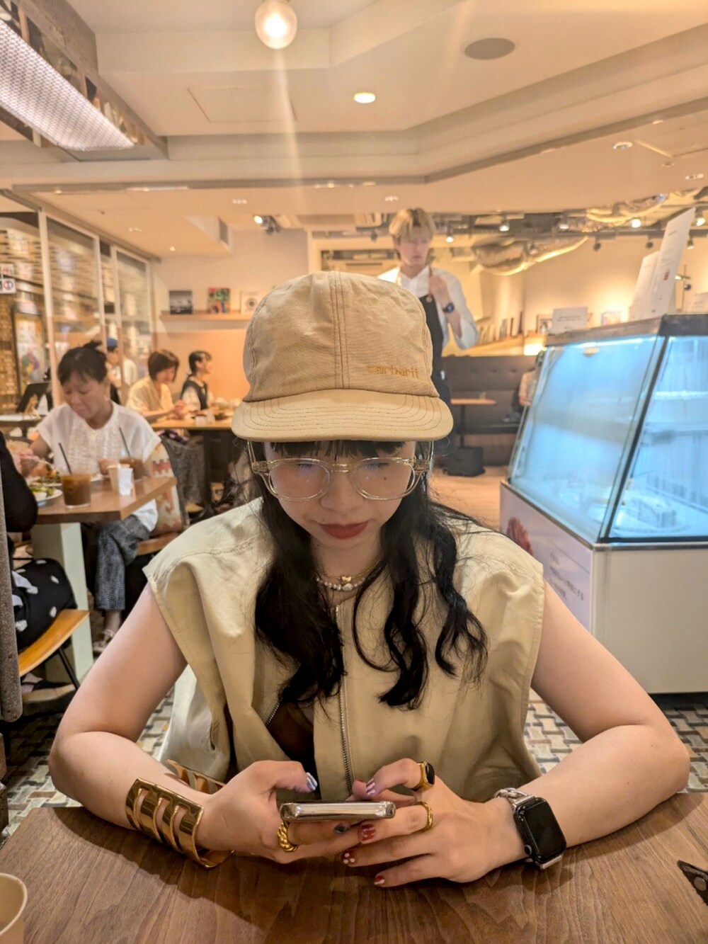 ベージュ系のベスト、ブラック系のデニムパンツ、ブラウン系のブーツを着用したレディースの秋コーディネートの4枚目の写真