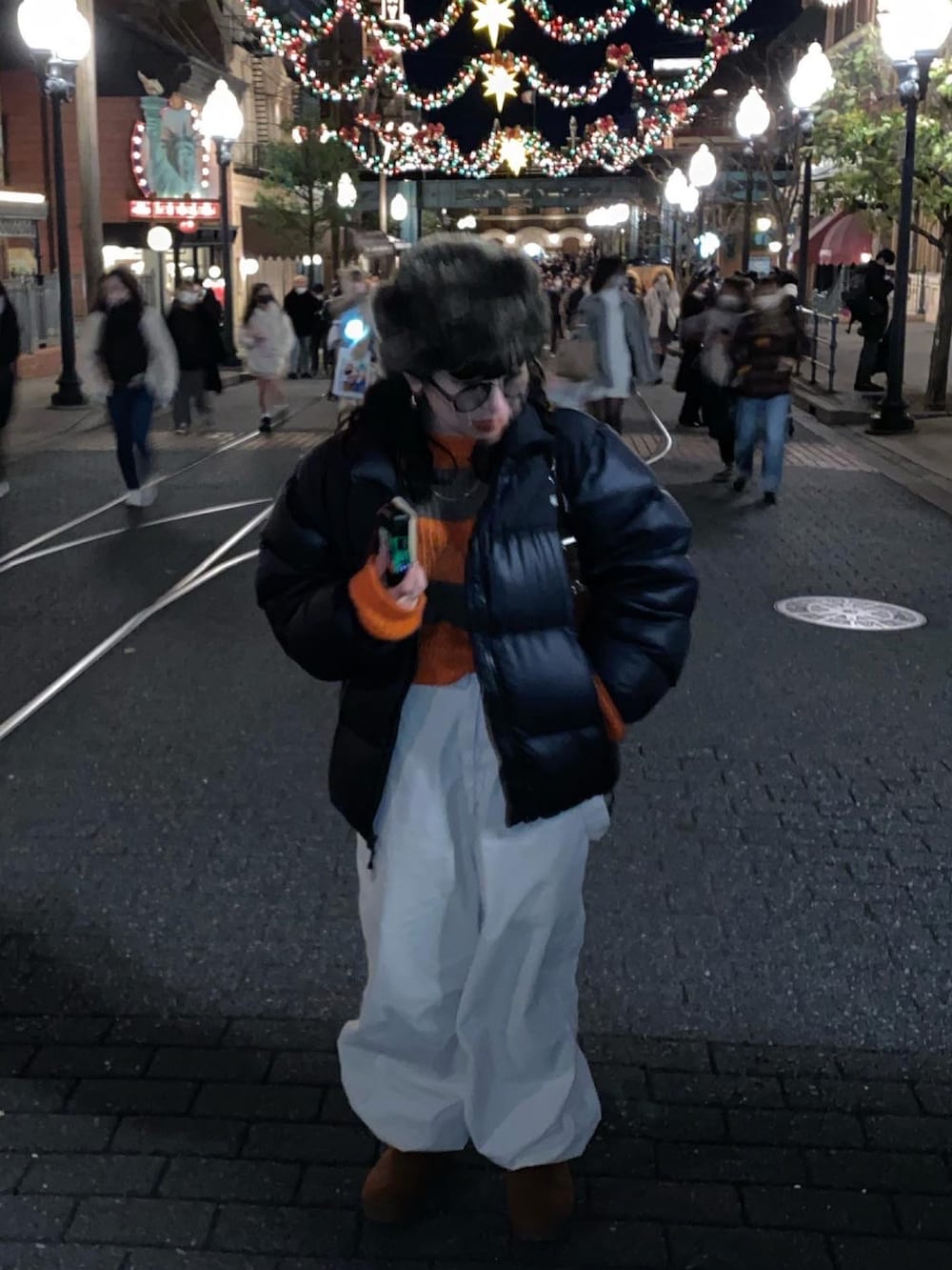 ブラック系のダウンジャケット/コート、ホワイト系のその他パンツ、ブラウン系のシューズを着用したレディースの冬コーディネートの2枚目の写真