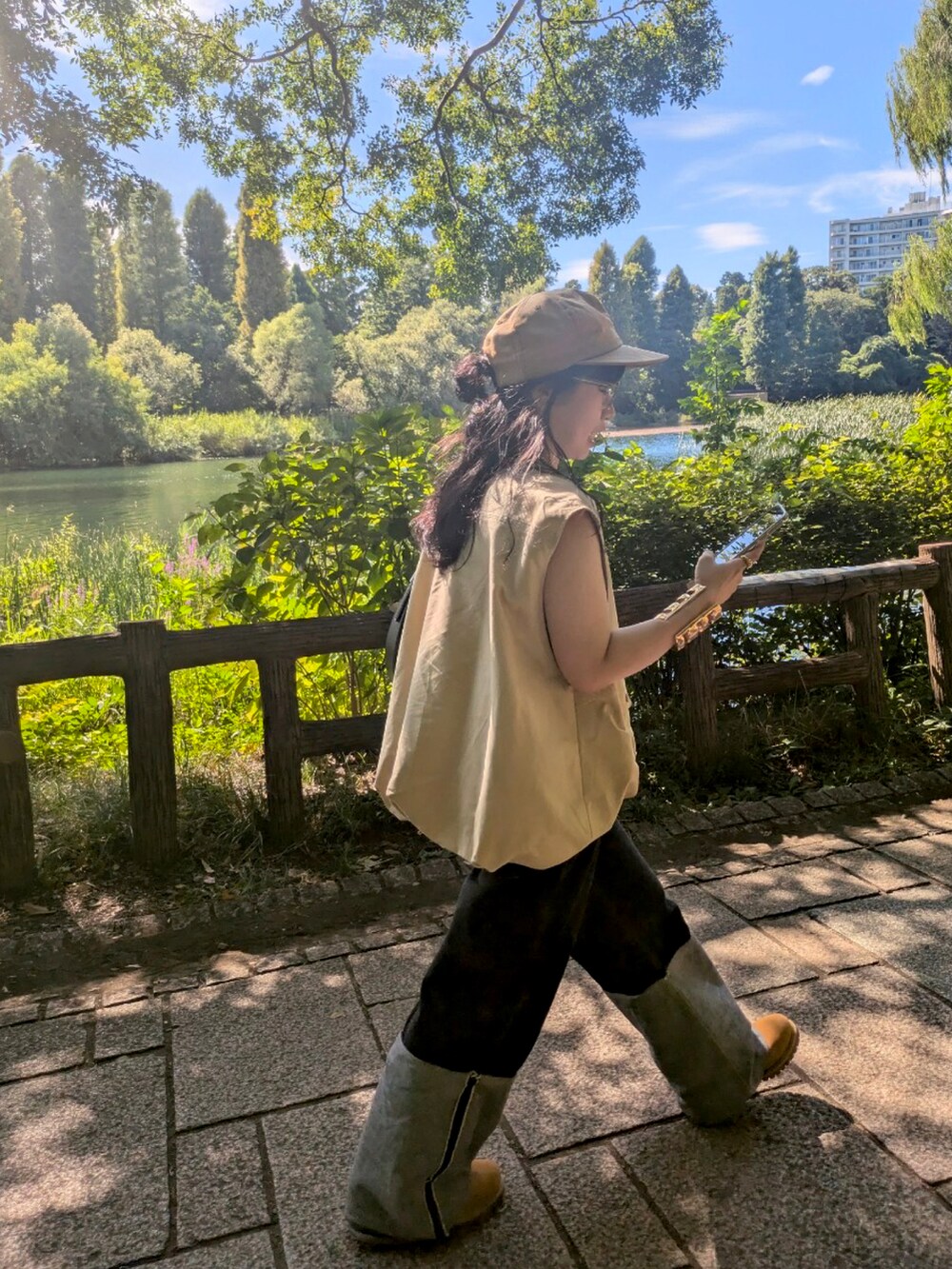 ベージュ系のベスト、ブラック系のデニムパンツ、ブラウン系のブーツを着用したレディースの秋コーディネートの2枚目の写真