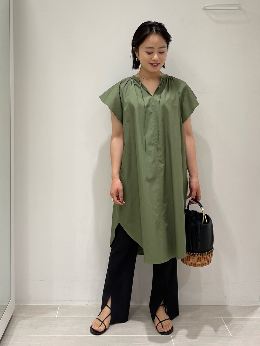 グリーン系のシャツ/ブラウス、ブラック系のスラックス、ブラック系のサンダルを着用したレディースの春コーディネートの2枚目の写真