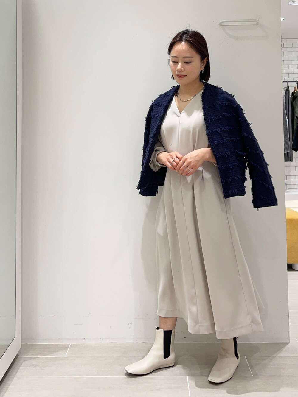 ベージュ系のワンピース、ブルー系のノーカラージャケットを着用したレディースの冬コーディネートの2枚目の写真