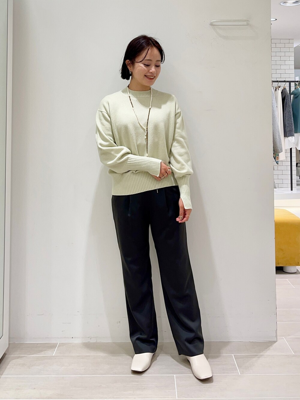 グリーン系のニット/セーター、グレー系のその他パンツを着用したレディースの冬コーディネートの2枚目の写真