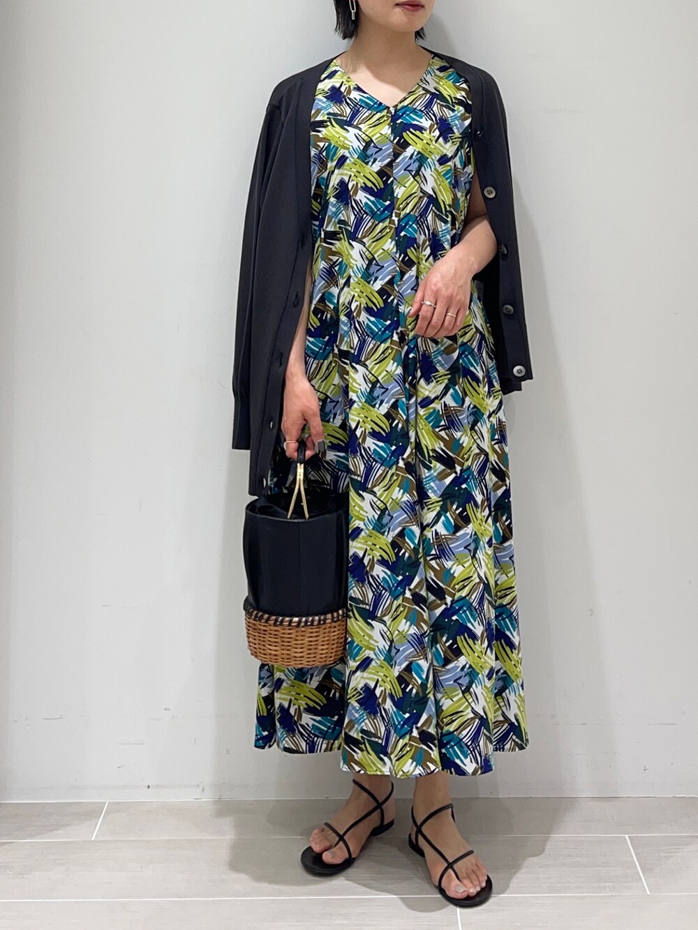 ブラック系のかごバッグ、その他のワンピース、グレー系のカーディガン/ボレロを着用したレディースの春コーディネートの2枚目の写真