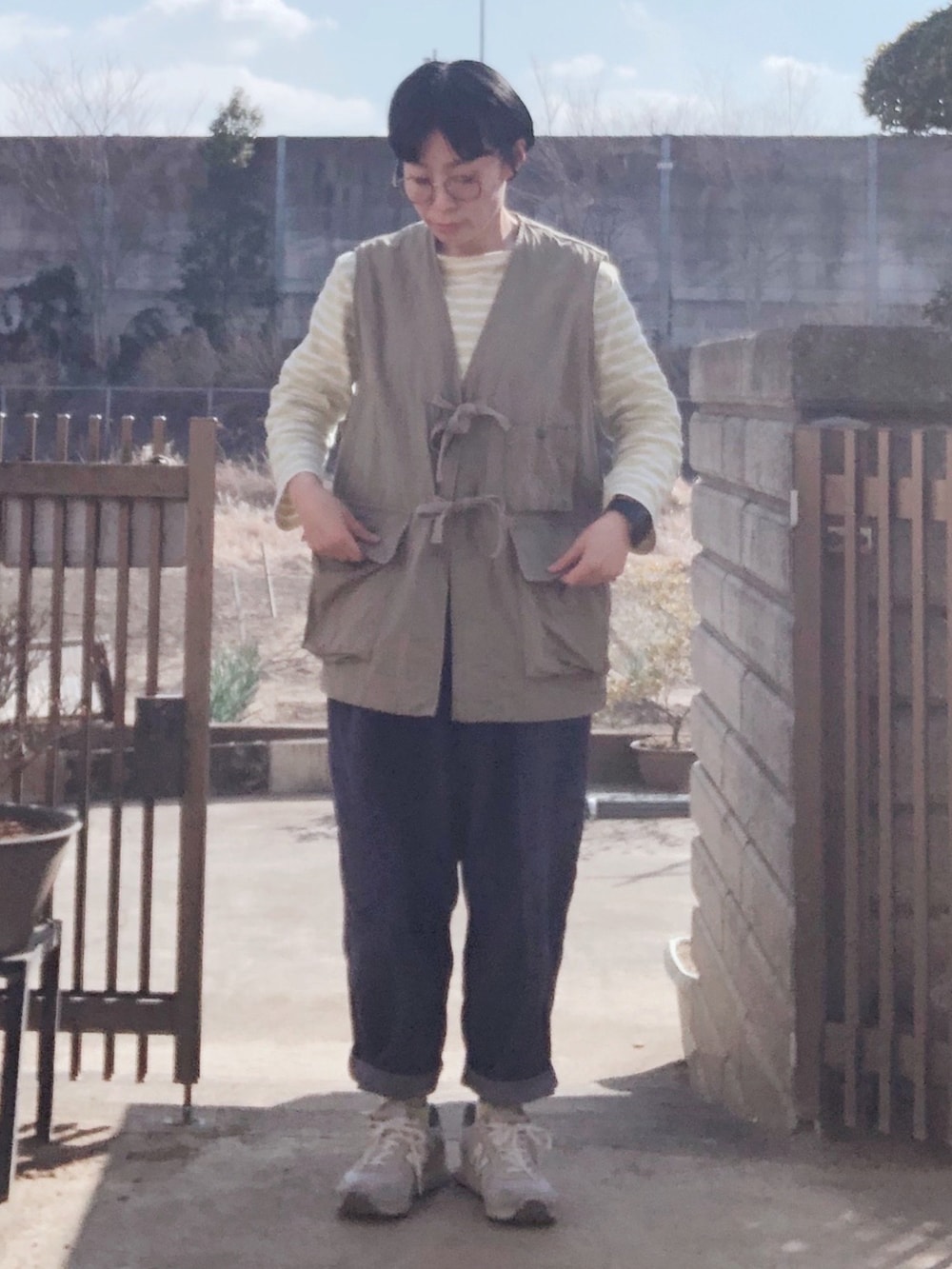 イエロー系のTシャツ/カットソー、グリーン系のベスト、ブルー系のその他パンツを着用したレディースの冬コーディネートの2枚目の写真