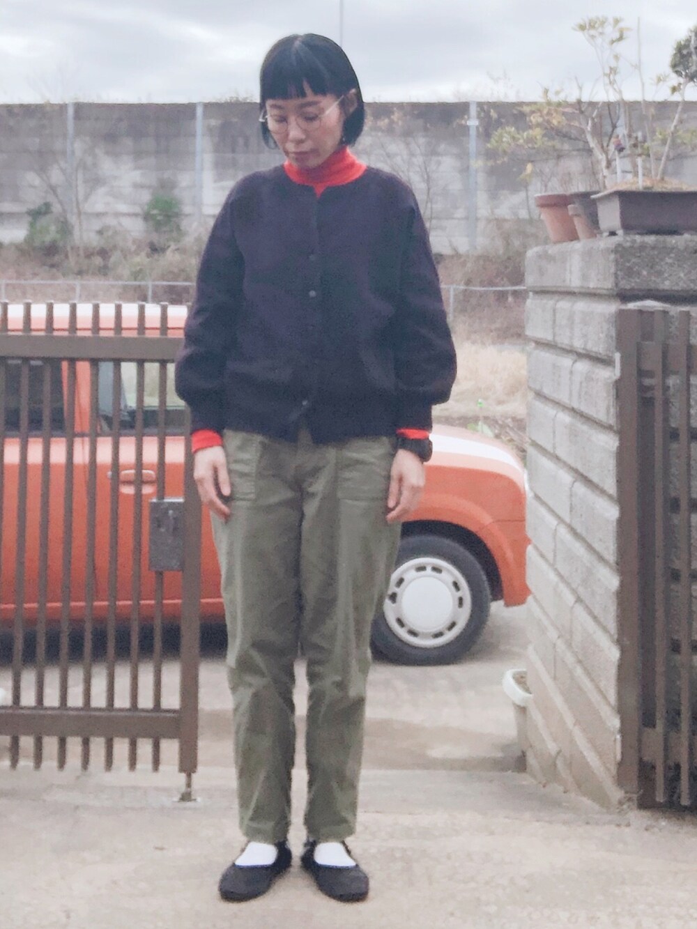 ブラック系のカーディガン/ボレロ、オレンジ系のトップス、グリーン系のその他パンツを着用したレディースの秋コーディネートの2枚目の写真