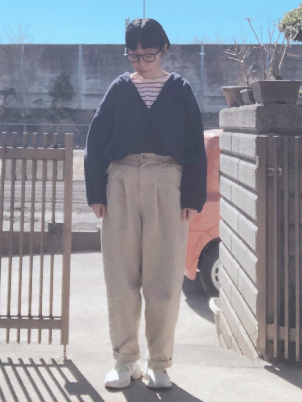 レッド系のTシャツ/カットソー、ブルー系のシャツ/ブラウス、ベージュ系のその他パンツを着用したレディースの春コーディネートの2枚目の写真