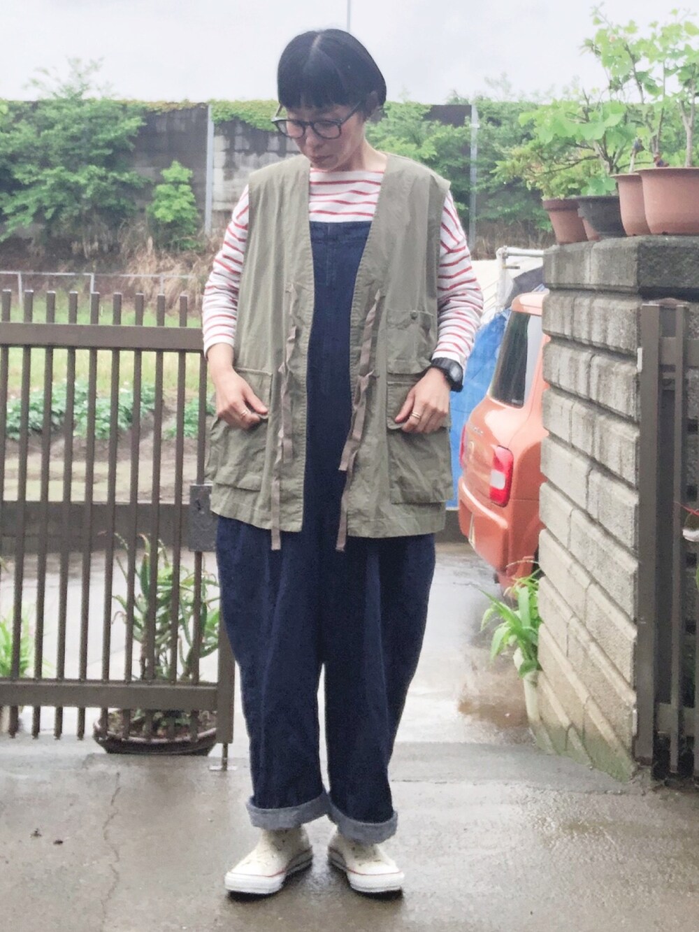 グリーン系のベスト、レッド系のTシャツ/カットソー、ブルー系のサロペット/オーバーオールを着用したレディースの春コーディネートの3枚目の写真