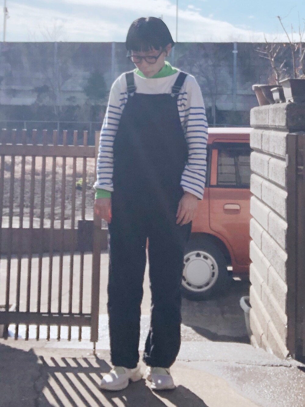 グリーン系のTシャツ/カットソー、ブルー系のTシャツ/カットソー、ブラック系のサロペット/オーバーオールを着用したレディースの冬コーディネートの2枚目の写真