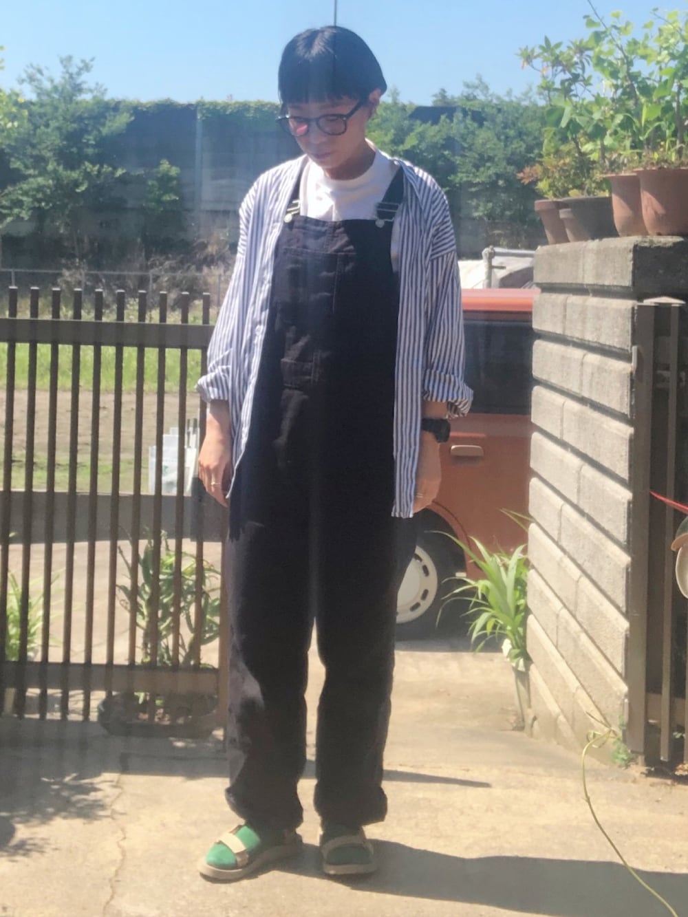 ホワイト系のTシャツ/カットソー、ブルー系のシャツ/ブラウス、ブラック系のサロペット/オーバーオールを着用したレディースの夏コーディネートの2枚目の写真