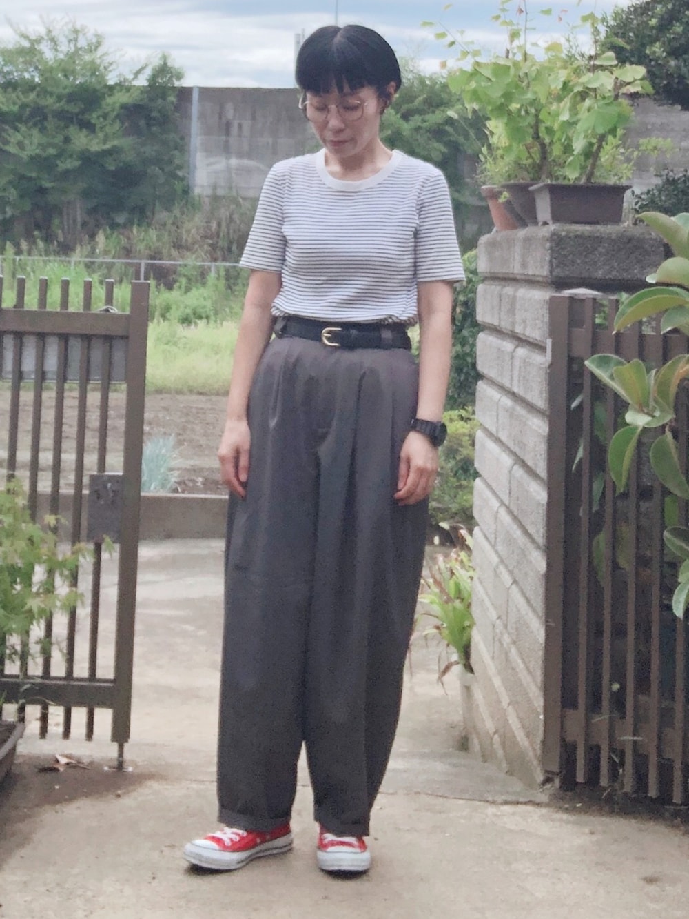 ホワイト系のTシャツ/カットソー、グレー系のスラックス、レッド系のスニーカーを着用したレディースの秋コーディネートの2枚目の写真