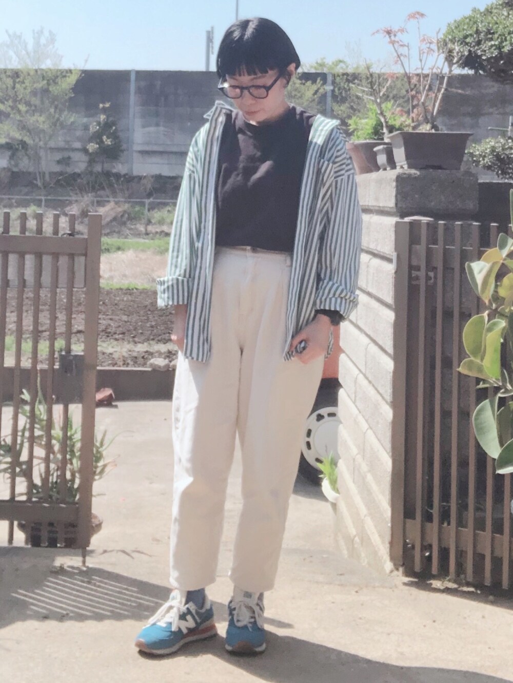 ブラック系のTシャツ/カットソー、グリーン系のシャツ/ブラウス、ホワイト系のデニムパンツを着用したレディースの春コーディネートの2枚目の写真