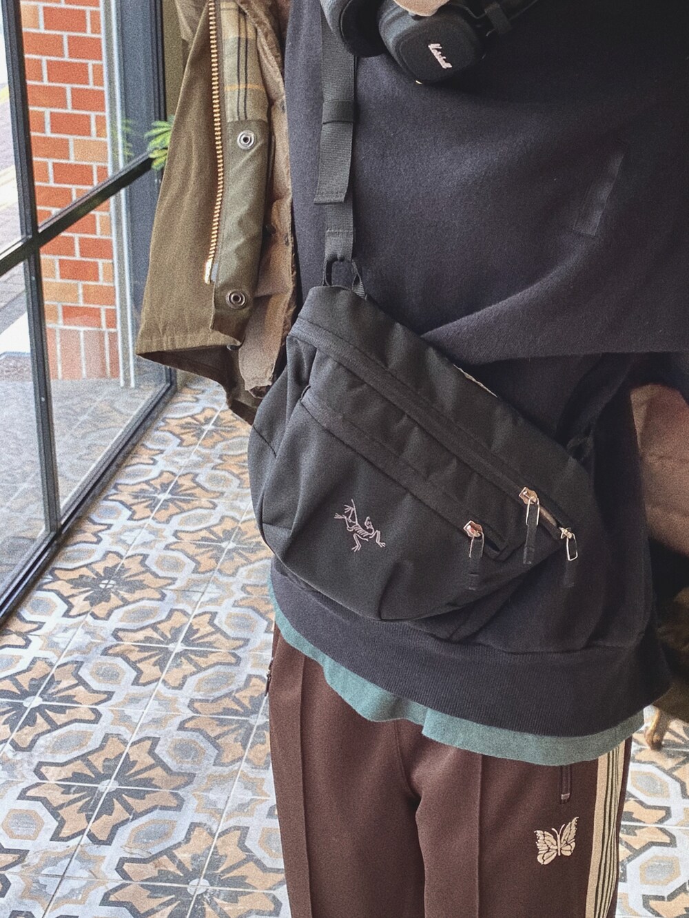 グリーン系のブルゾン、ブラウン系のその他パンツ、ブラック系のボディバッグ/ウエストポーチを着用したレディースの冬コーディネートの2枚目の写真